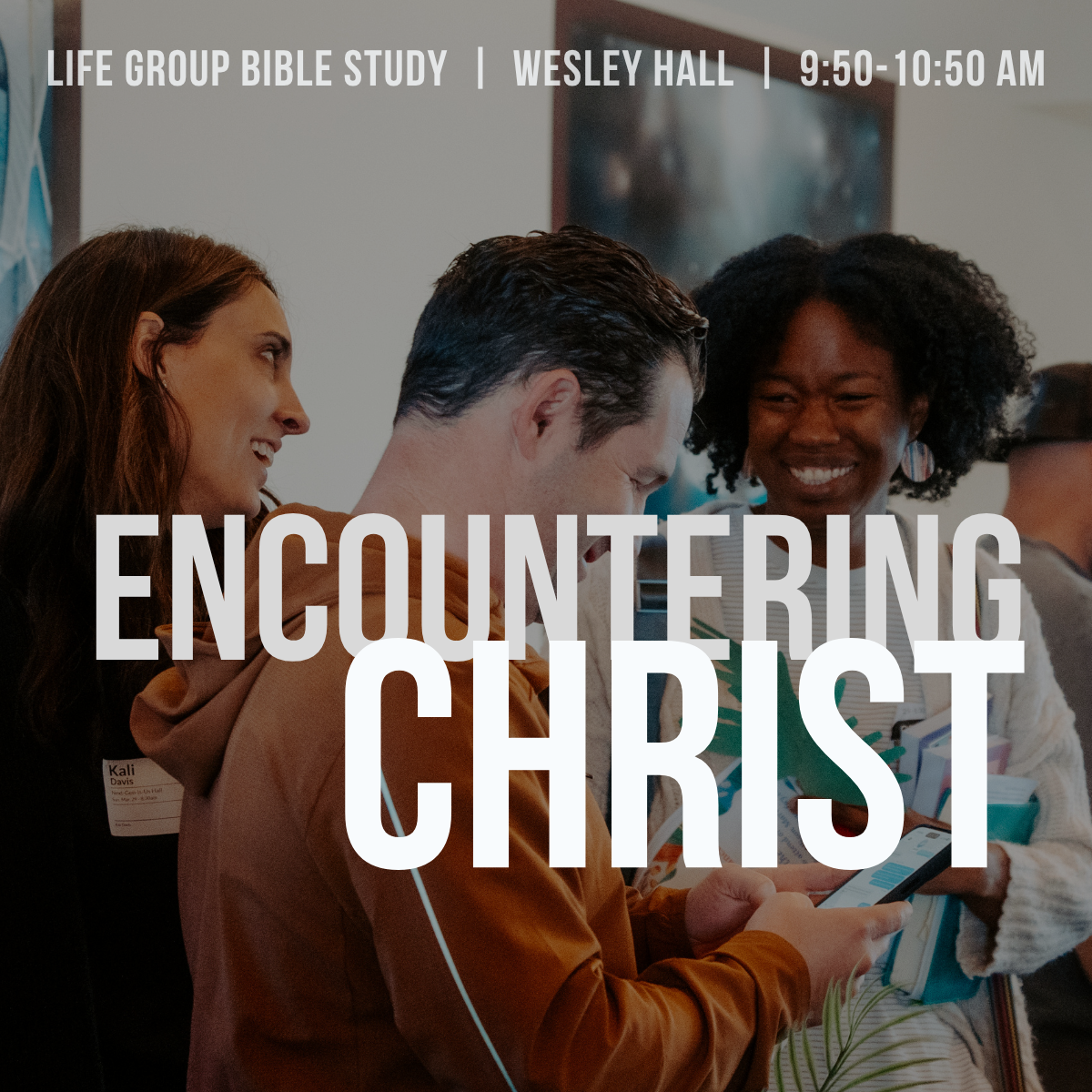 Group of people at a Bible study meeting, smiling and engaging with each other, in Wesley Hall at 9:50 to 10:50 AM.