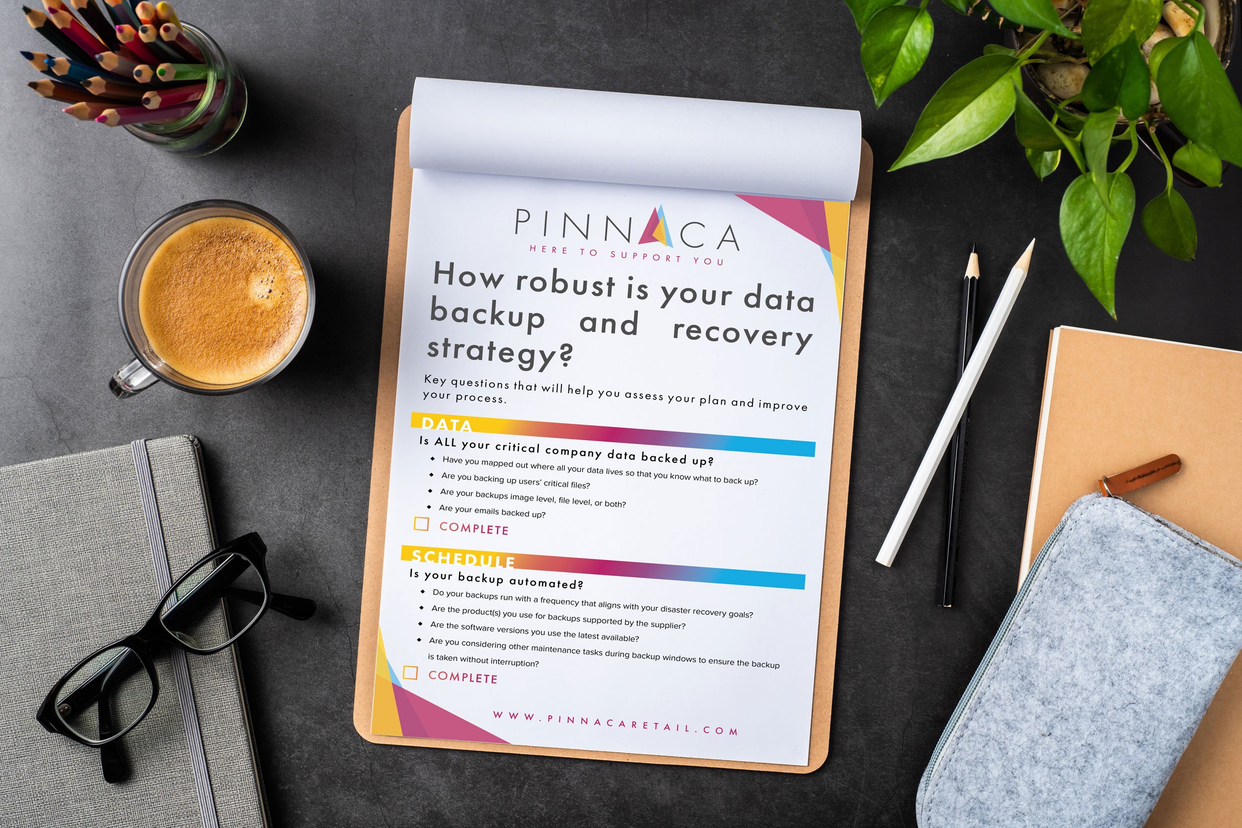 A wooden clipboard sitting on a desk with a paper checklist clipped to it titled How robust is your data and recovery strategy?