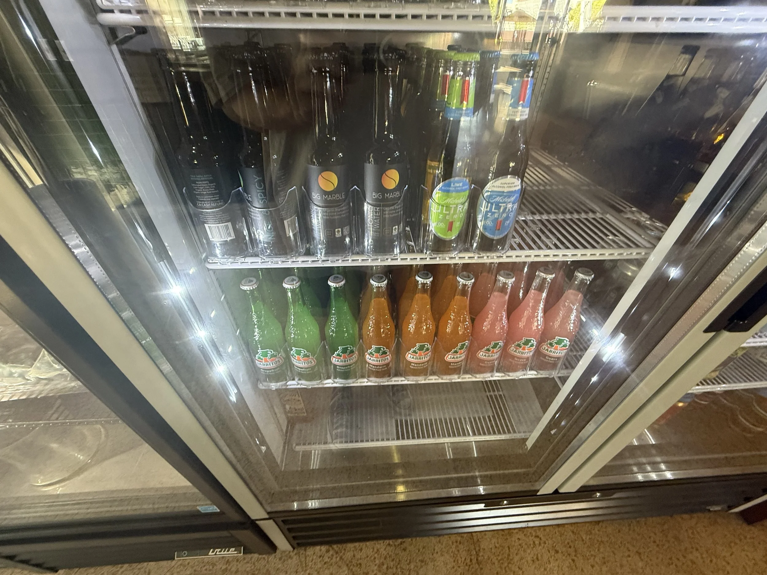 Inside a refrigerated display case with bottled beverages, including different flavors of soda and sparkling water.“Indoor event space at Park Central in Phoenix, Arizona, where the Phoenix Arcadia Rotary Club hosts its annual poker tournament