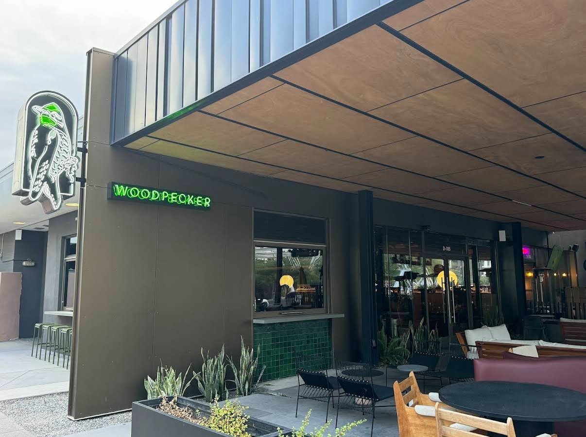 Exterior view of a restaurant Named "The Green Woodpecker" In Park Central a modern building development in DownTown Phoenix Arizona. Featuring Phoenix Arcadia Rotary Club Poker Tournament location, and a logo featuring a woodpecker on the wall.