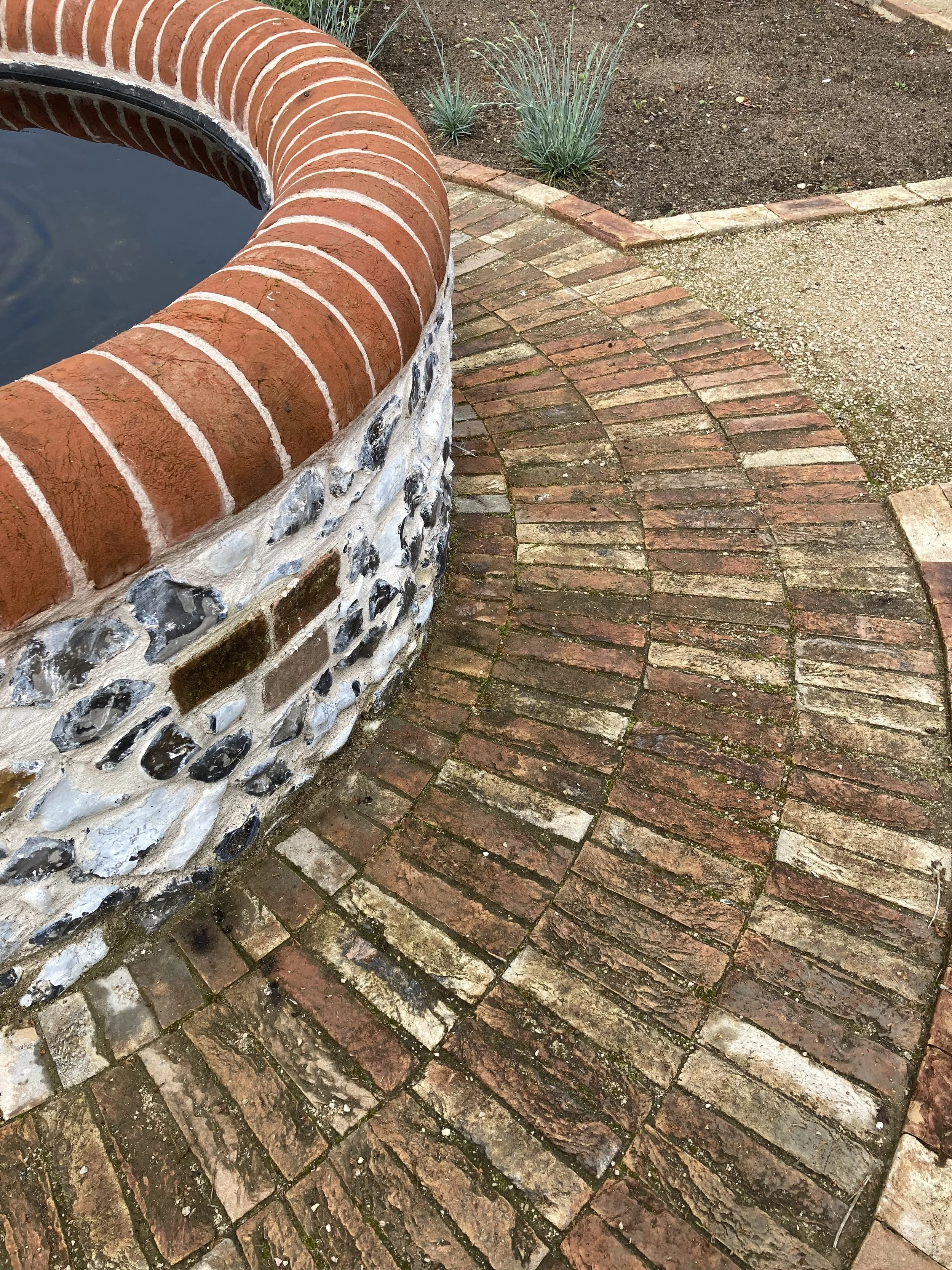 Reclaimed bricks on edge create a striking base for this water feature in the Cutting Garden. 