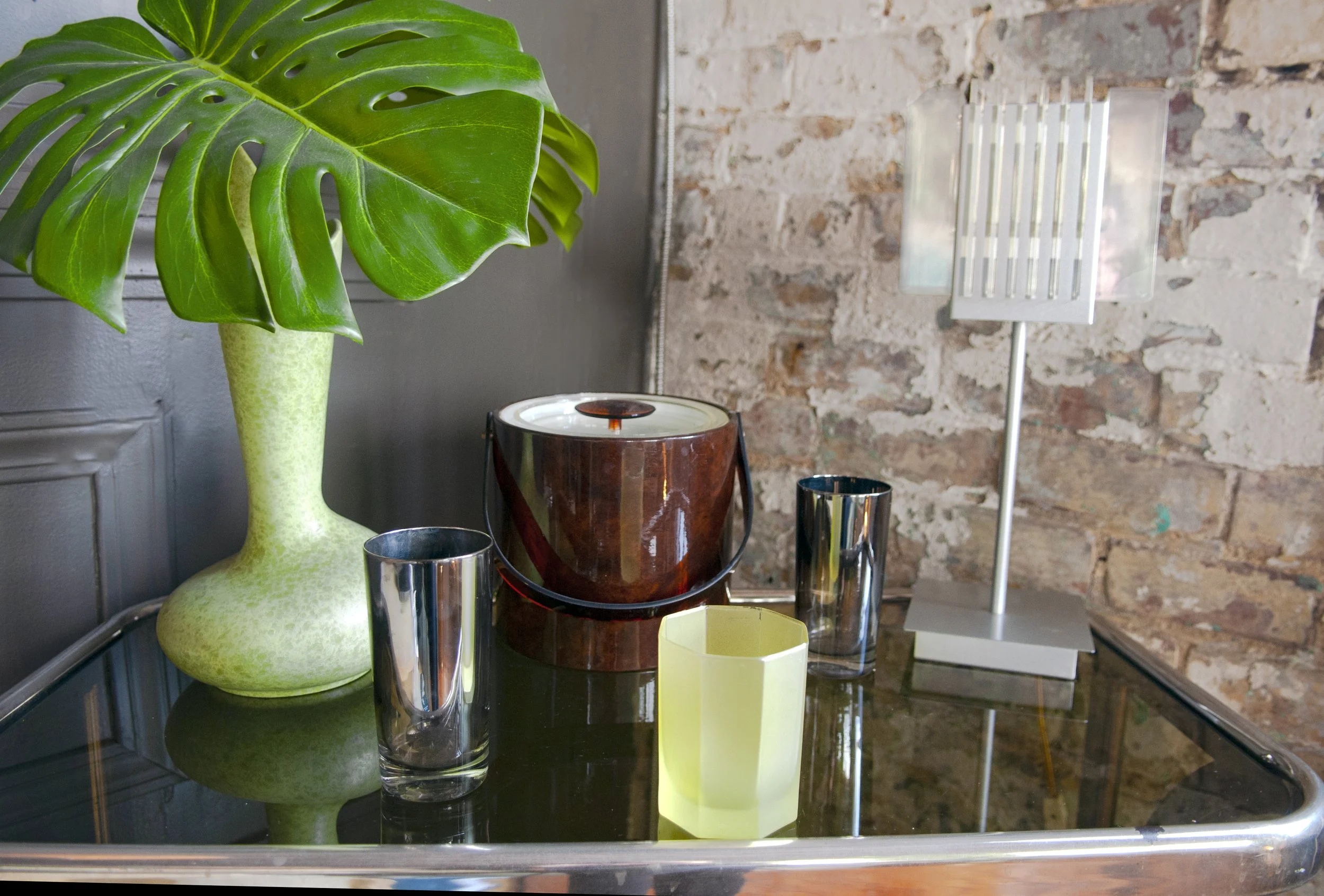 House of No Era's former historic loft studio in Camp Washington, Cincinnati, featuring a vignette of retro bar-top décor and vintage glassware.

