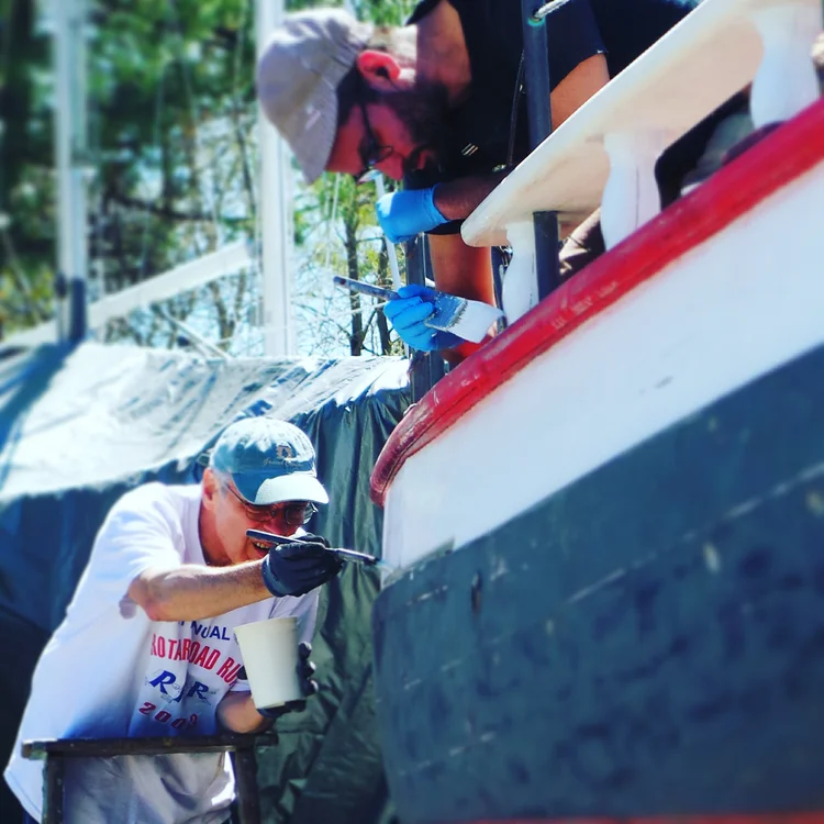 Volunteer painting CHRISTEEN during seasonal maintenance