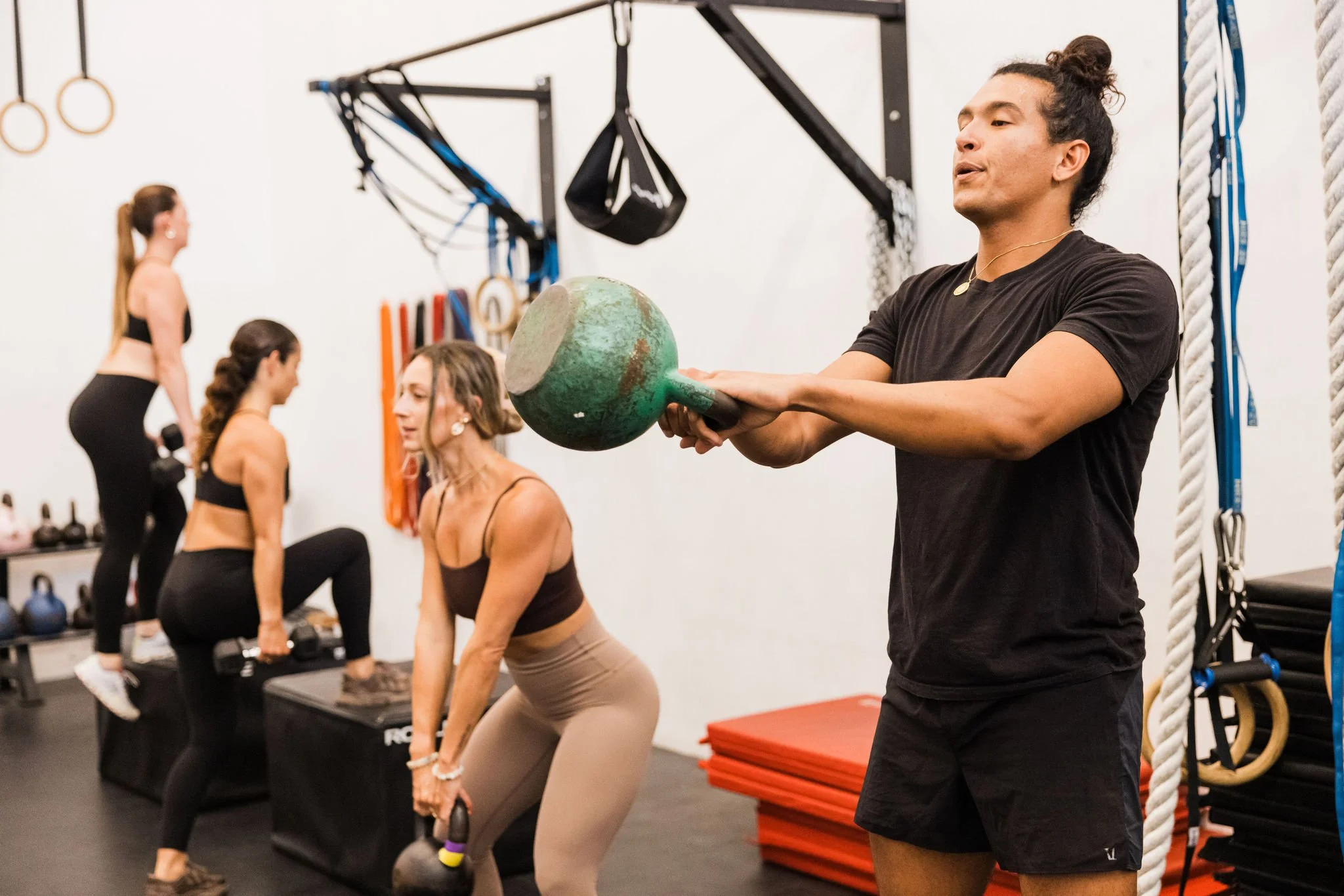 Members using kettlebells during an unheated strength training class at Asteya in Encinitas.