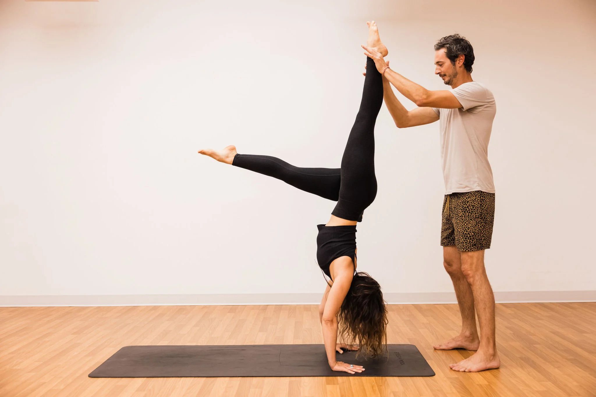Student in handstand at Asteya Collective Studio in Encinitas, CA