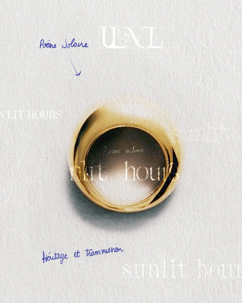 Close-up of a golden ring on a white background with handwritten notes and stamped text, including French phrases 'Poeme Solaire' and 'Heritage et transmission'.