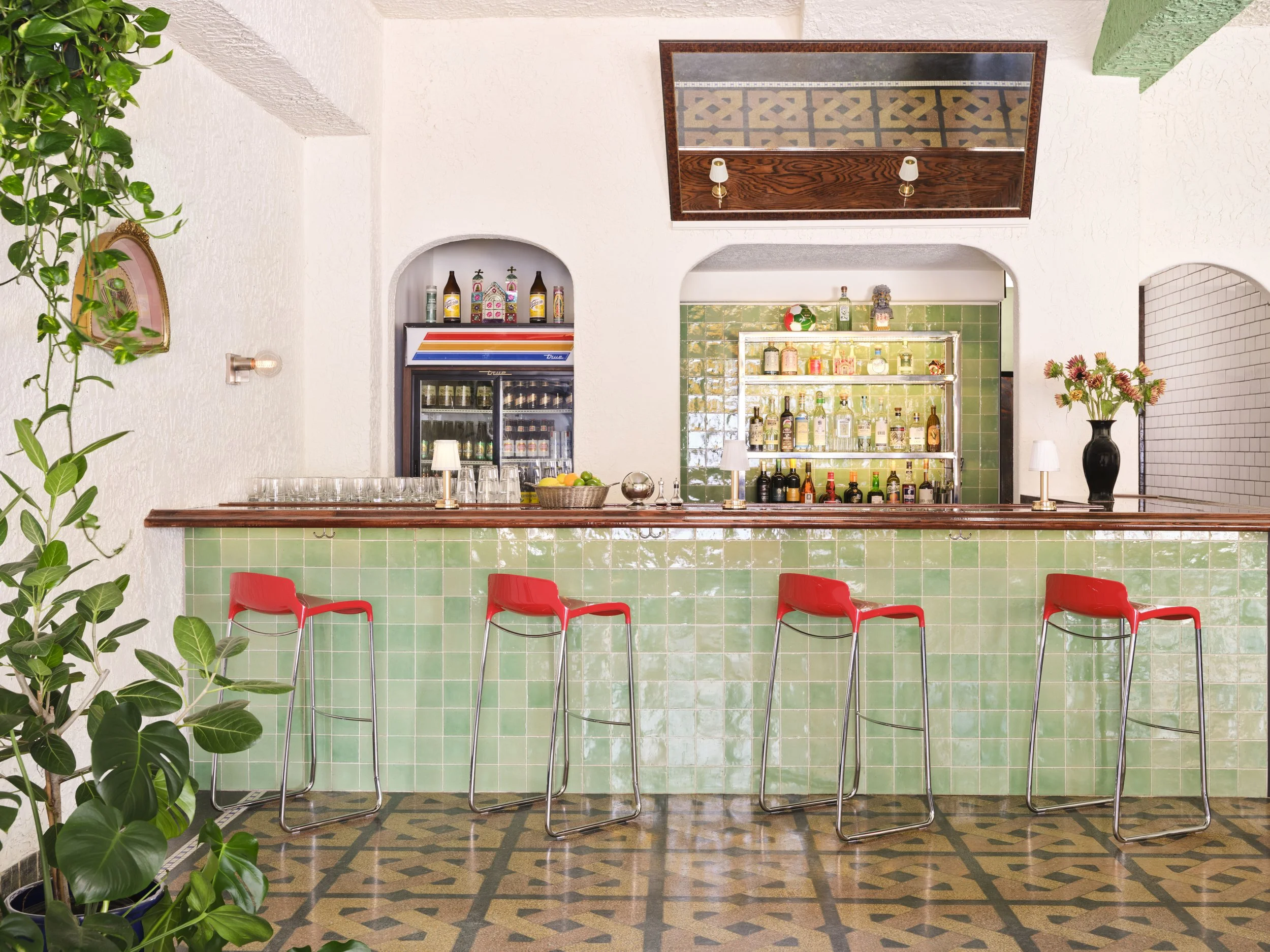 Tiled bar with arches and bright red bar stools