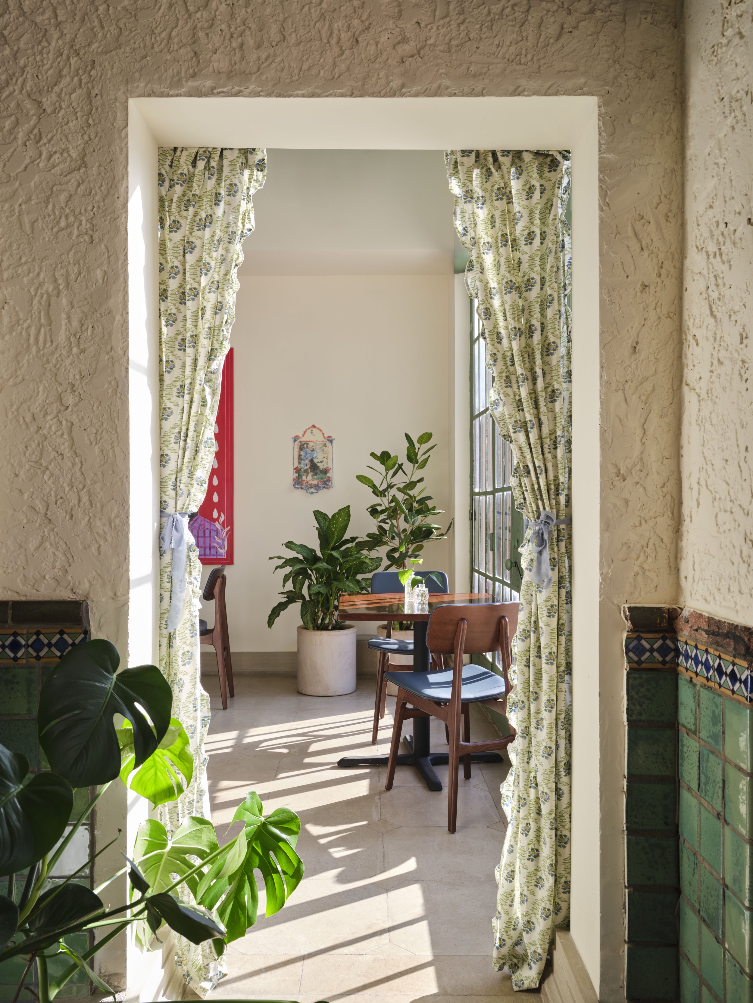 View into the secondary dining room through floral curtains