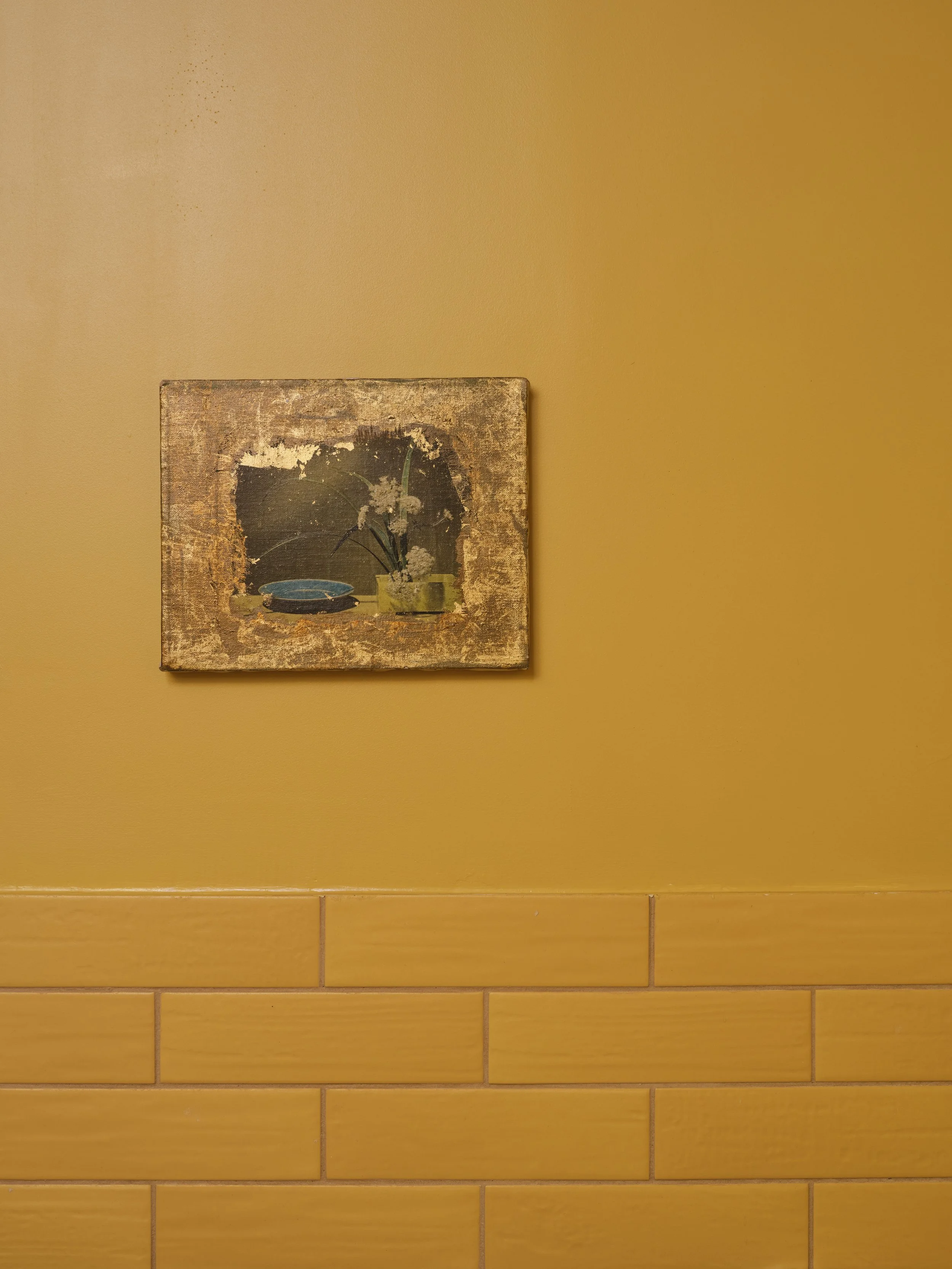 Yellow color-washed walls with tile and a small vintage painting