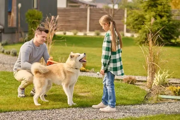 Father and daughter bonding with dog