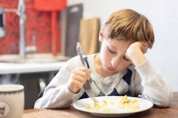 A child having trouble eating his food.