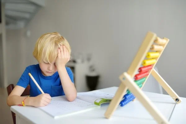 A child losing focus while writing.