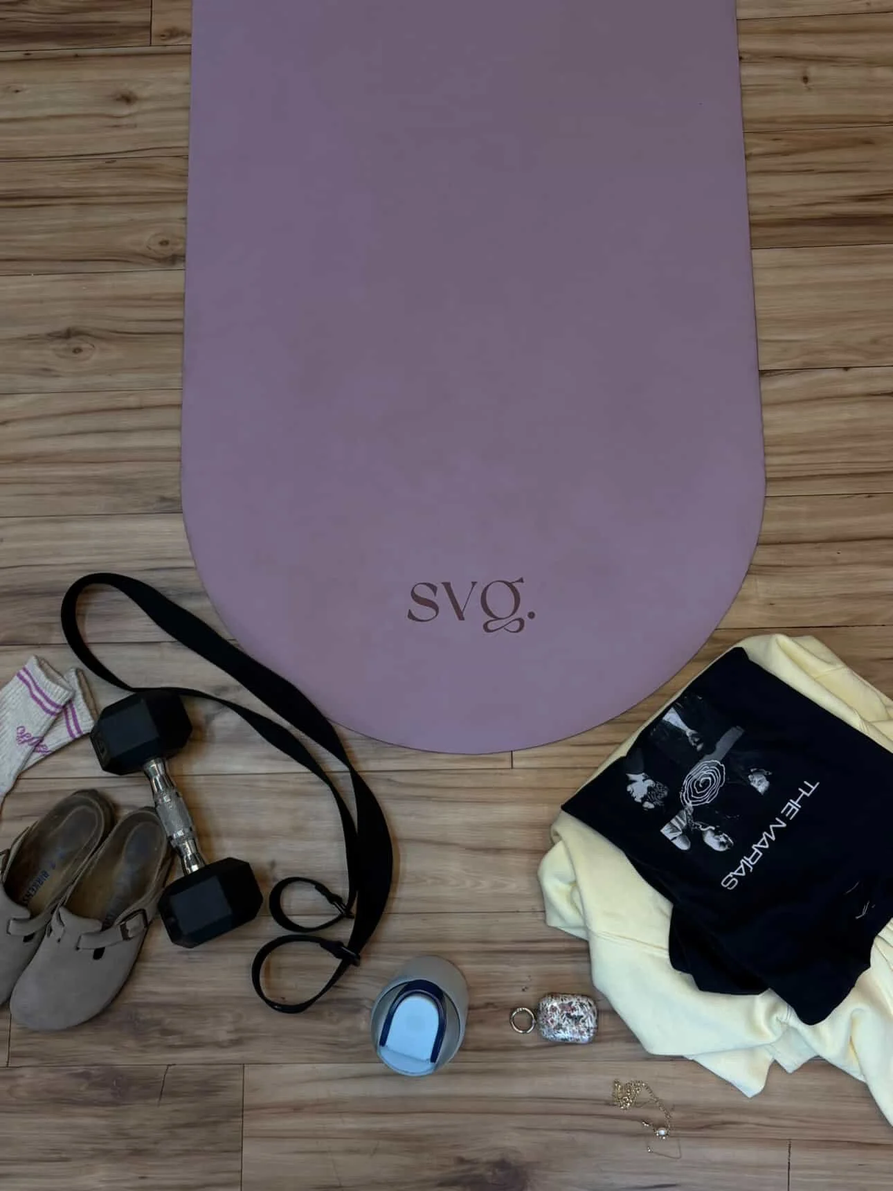 The lila serena capsula mat laid out on the hardwood floor with training equipment surrounding it.