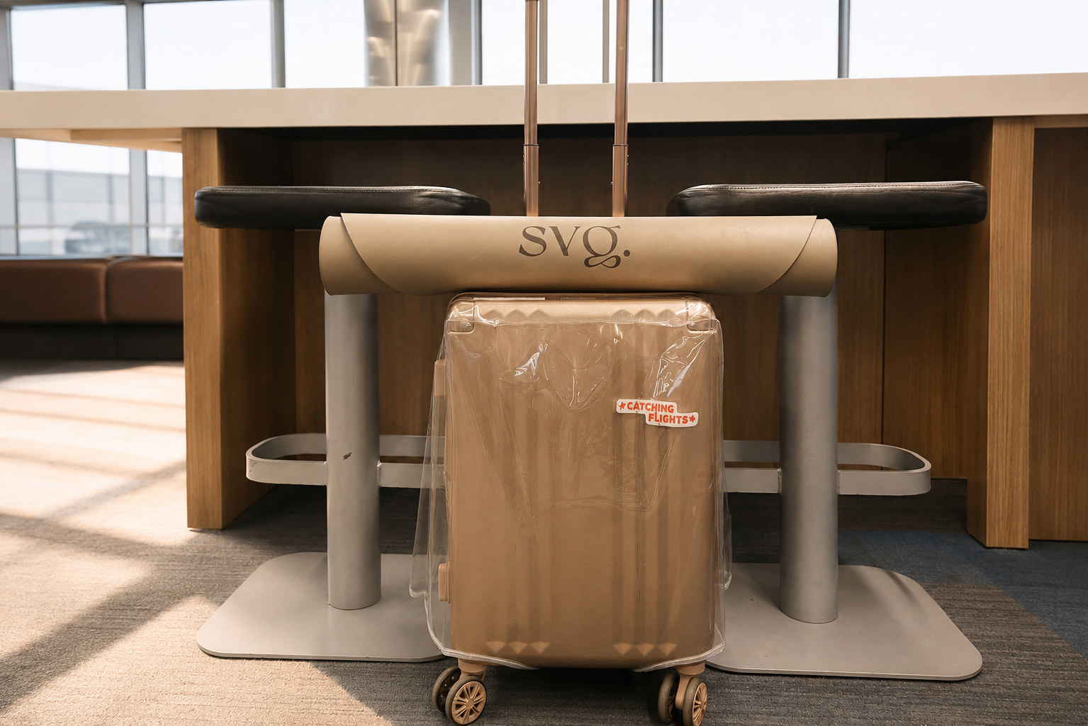 The Perla de Leche Capsula Wellness Mat rolled tightly ontop of a carry-on luggage in an airport lounge.