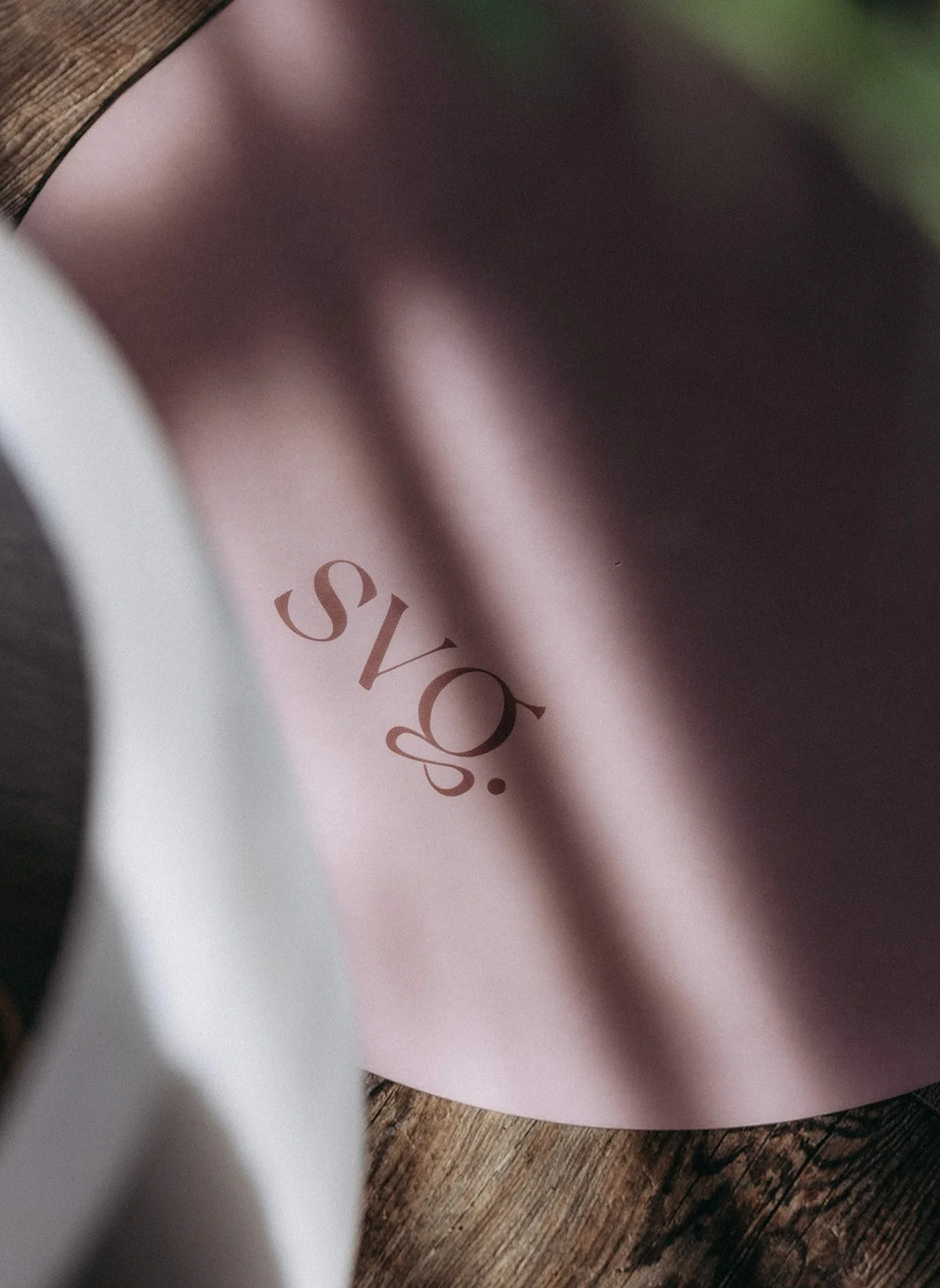 A detail shot of the svg. logo on the Lila Serena Capsula Mat with warm shadows cast over it.