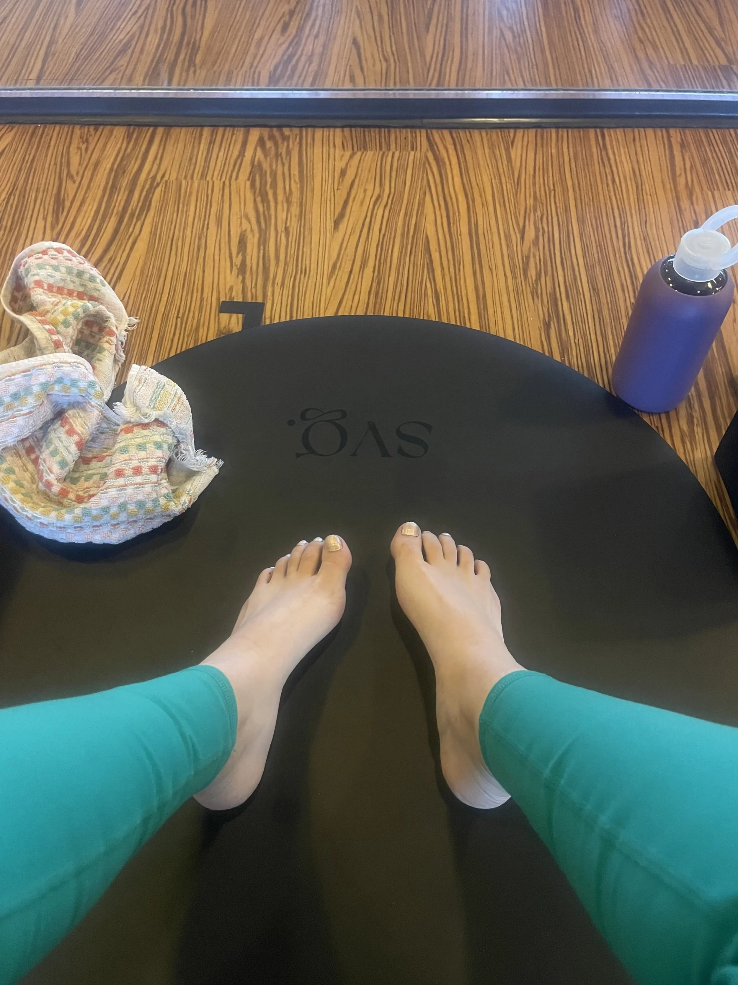 Shot of the top edge of the negro mate capsula mat with a focus on the logo surrounded by a towel and water bottle.