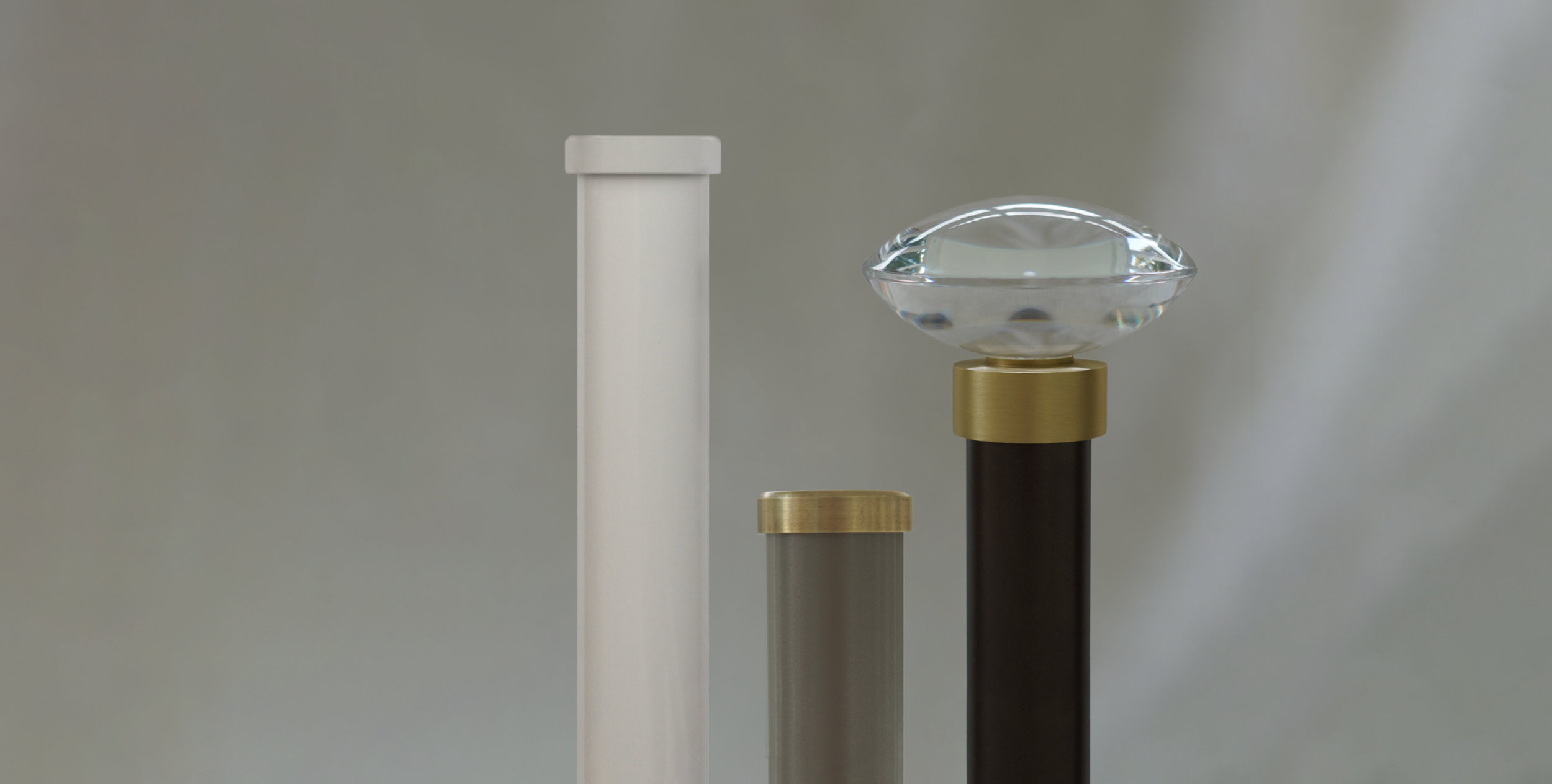 Three modern curtain pole profiles, Distinction 28 and 35, with different heights and designs, topped with end caps, brass end caps, and acrylic decorative discus finial with brass collar