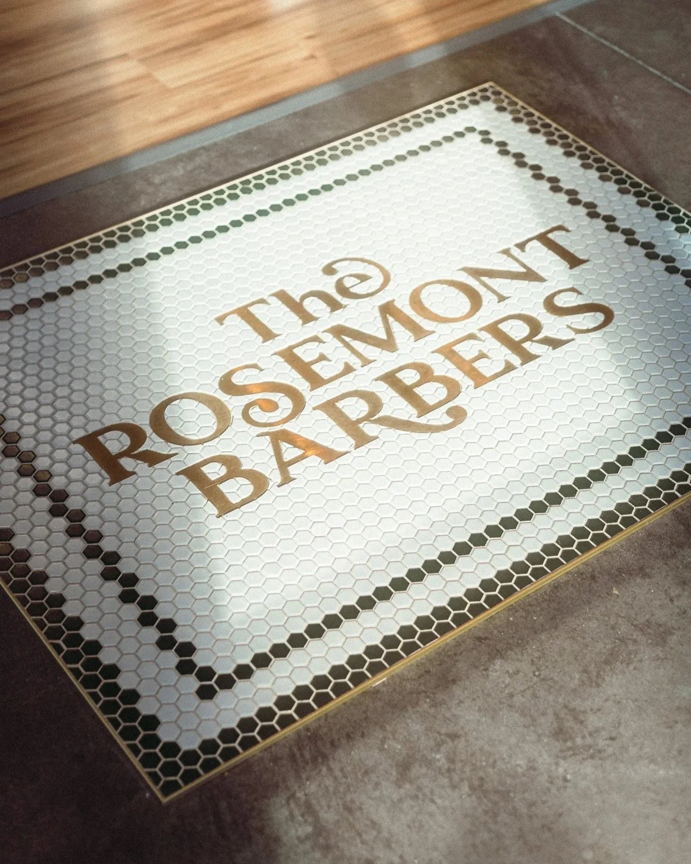 Logo tile mat at The Rosemont Barbers best barbershop in Denver. 