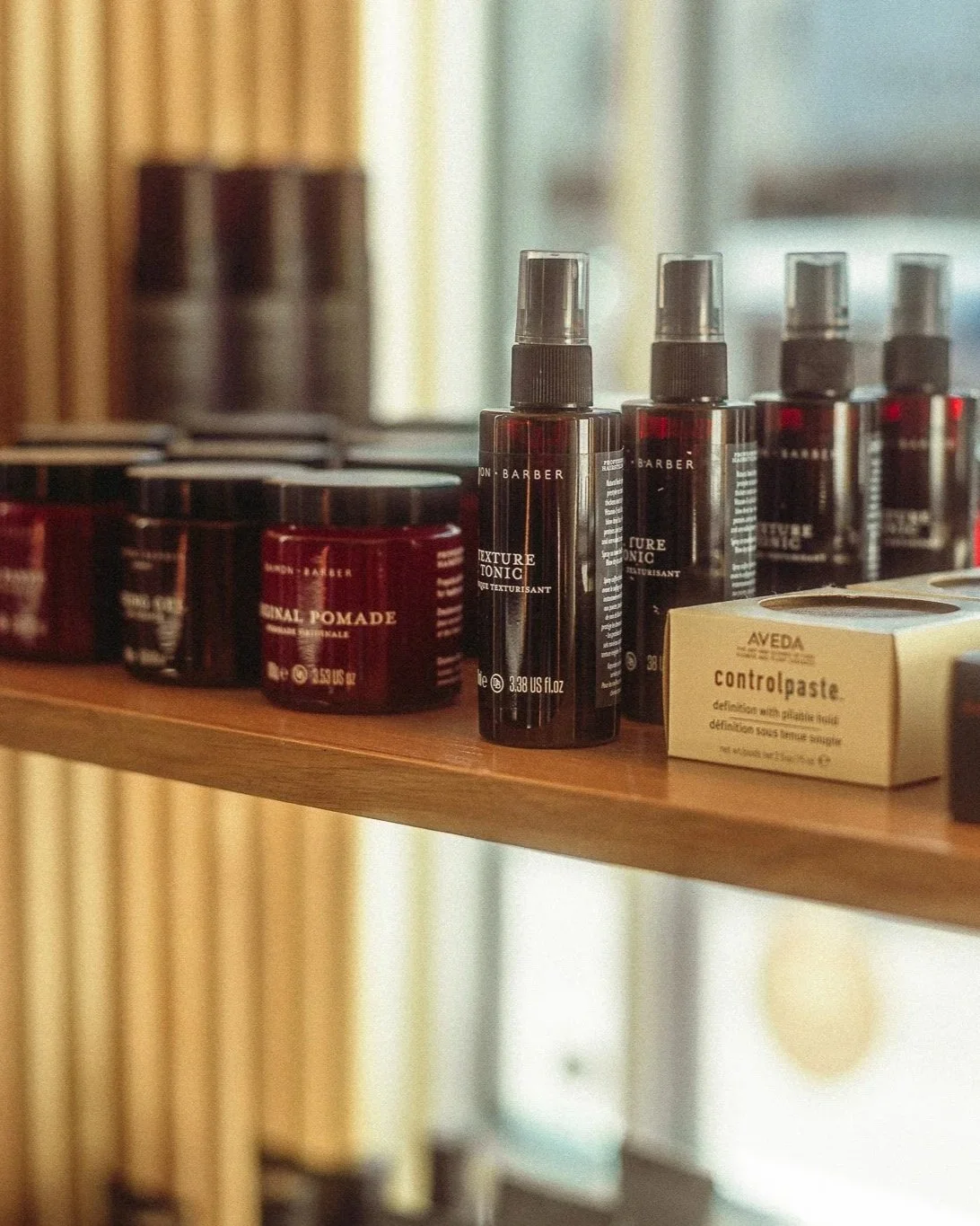 Premium men's styling products and grooming essentials displayed on retail shelving at The Rosemont Barbers RiNo.