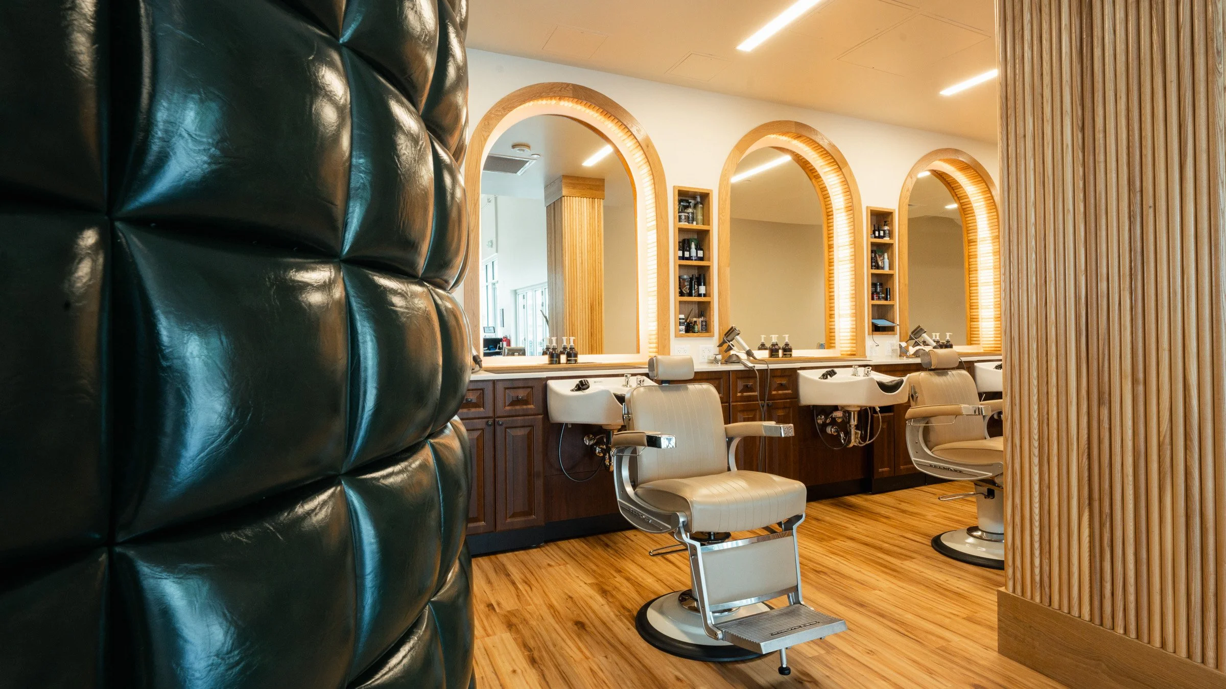 Junior Barber at The Rosemont performing a haircut during their training phase, wearing standard Rosemont attire before earning their custom barber jacket.