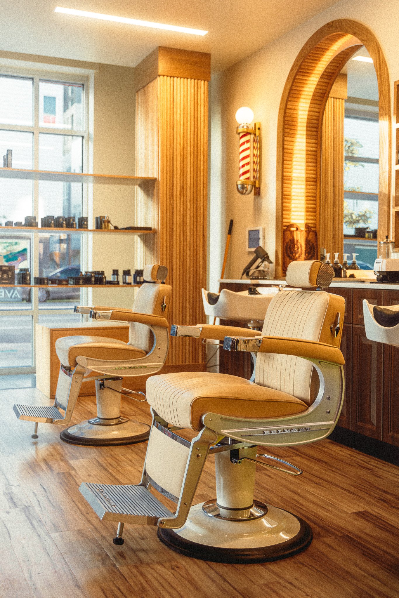 Classic leather barber chair and custom walnut millwork inside The Rosemont Barbers RiNo shop on Larimer Street in Denver.