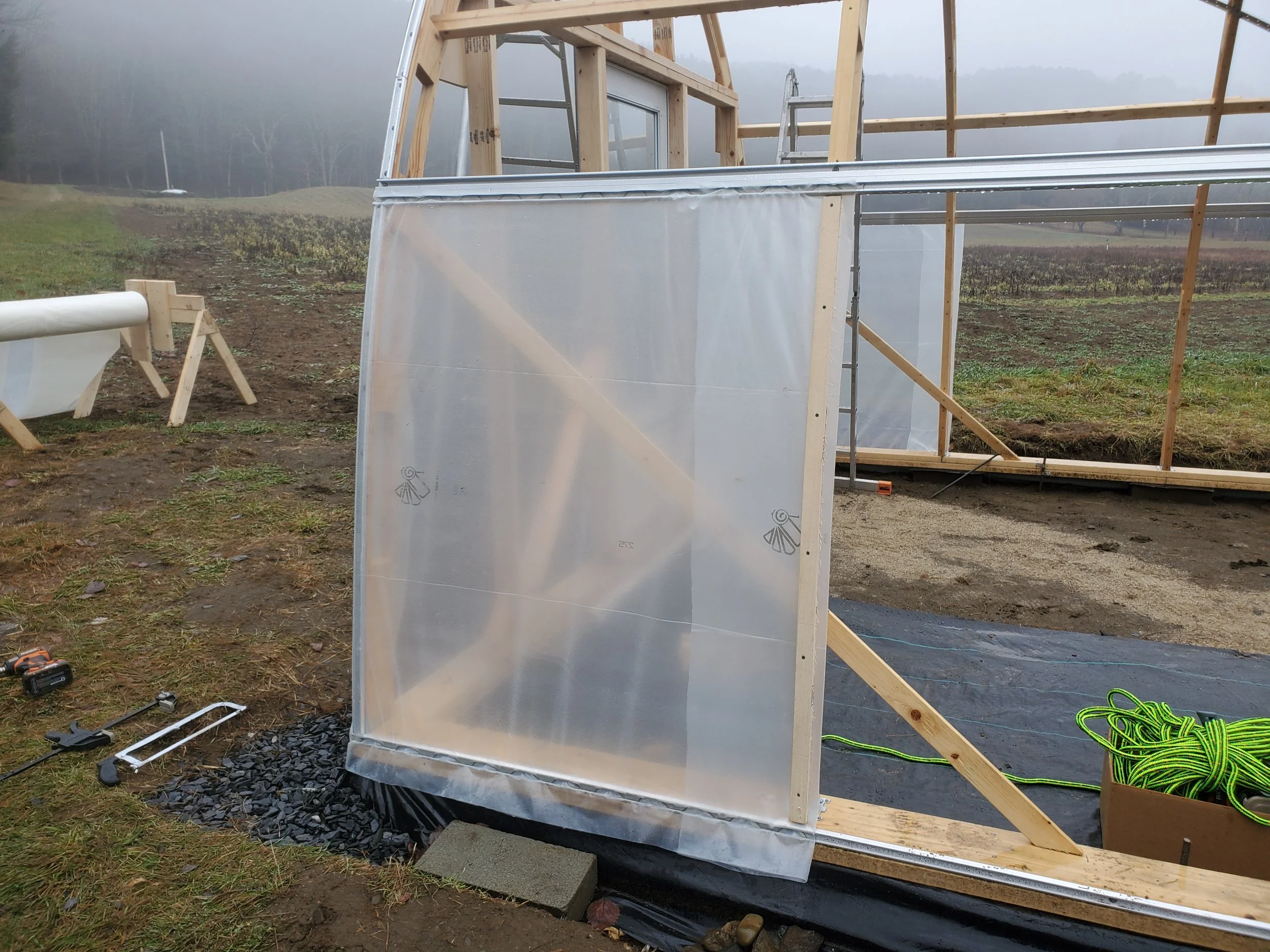 Plastic sheeting on end panels to minimize cross breezes of side curtains