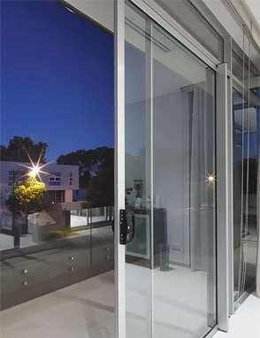 Sliding glass doors with night view of modern buildings and trees