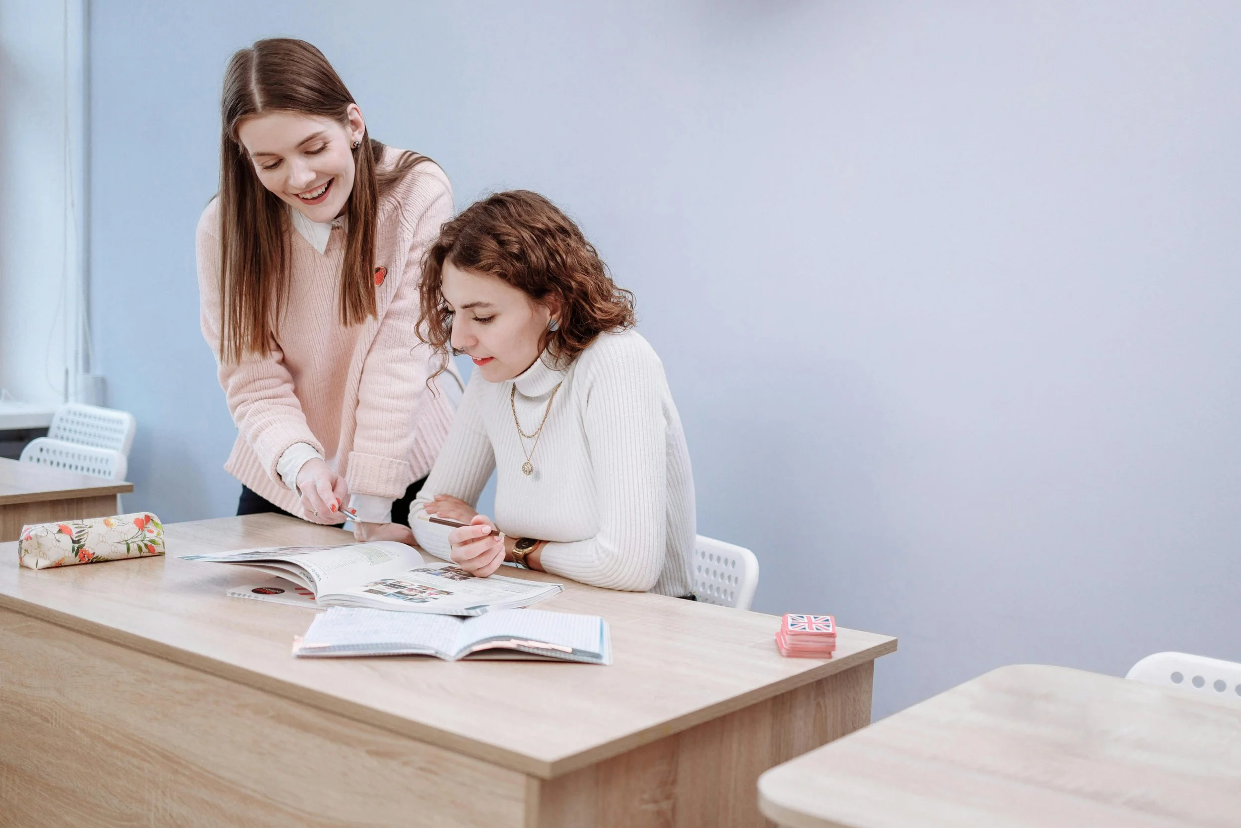 Two women studying together and reviewing notes while working toward their goals and plans.