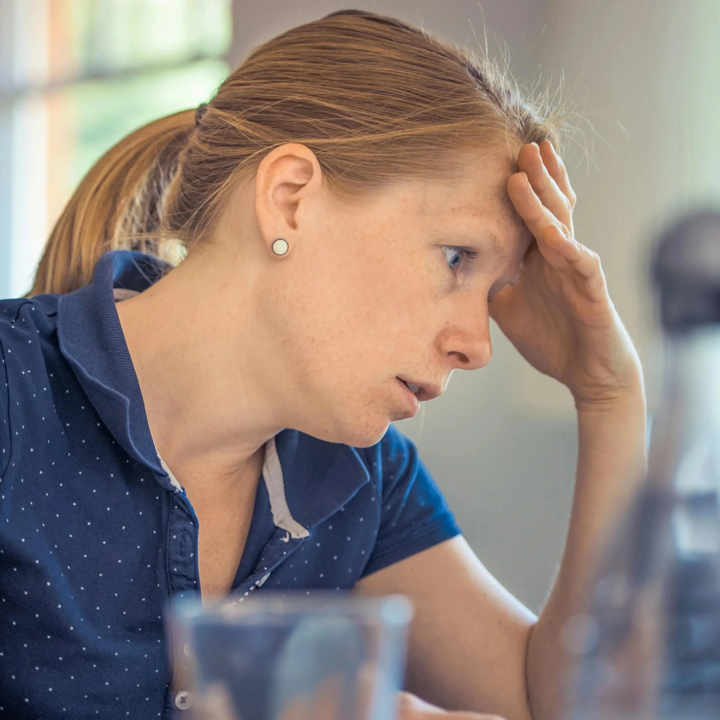 Woman working on a laptop looking overwhelmed while trying to complete tasks and execute her plans.