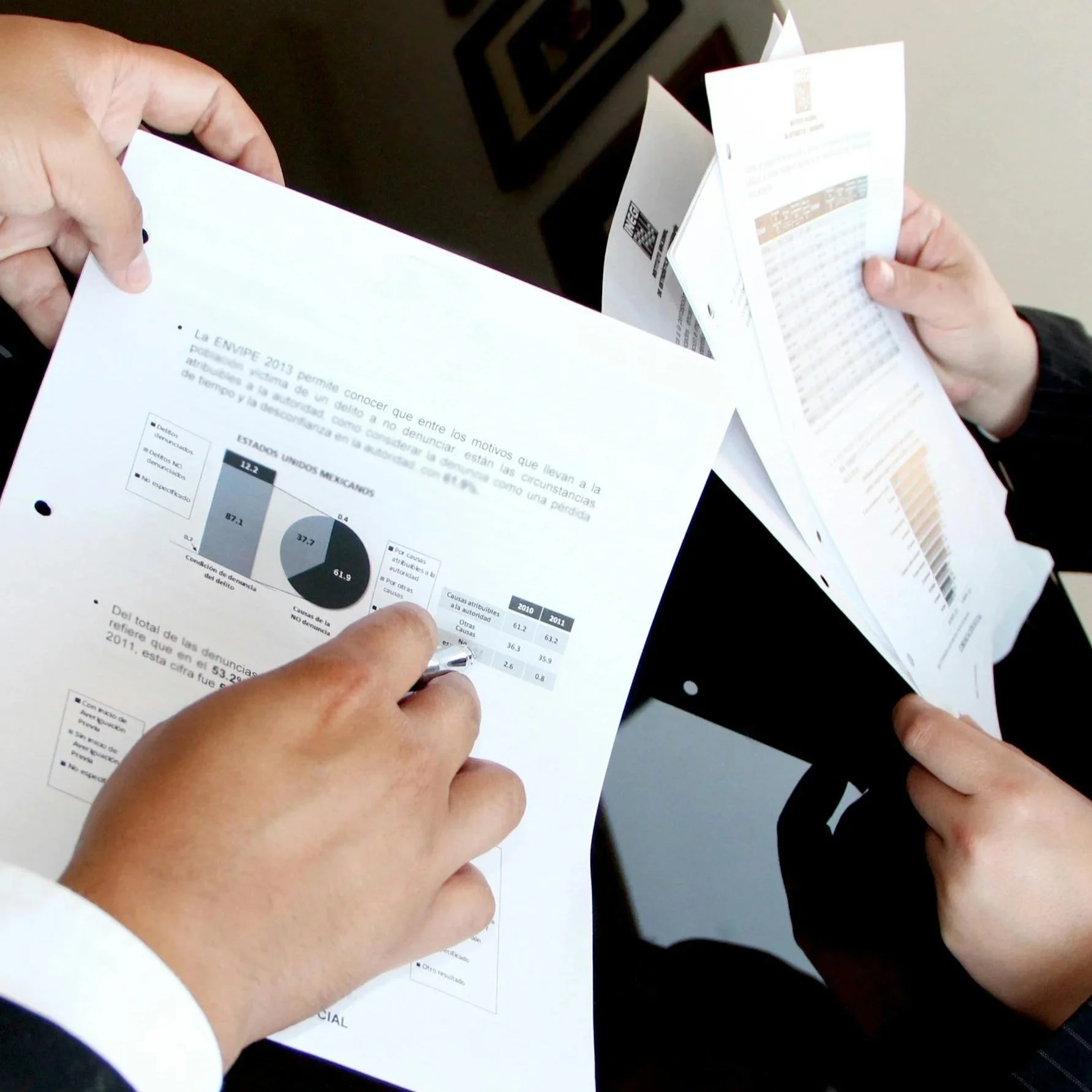 Business professionals reviewing printed charts and performance reports, representing tracking metrics, analyzing data, and engineering measurable outcomes.