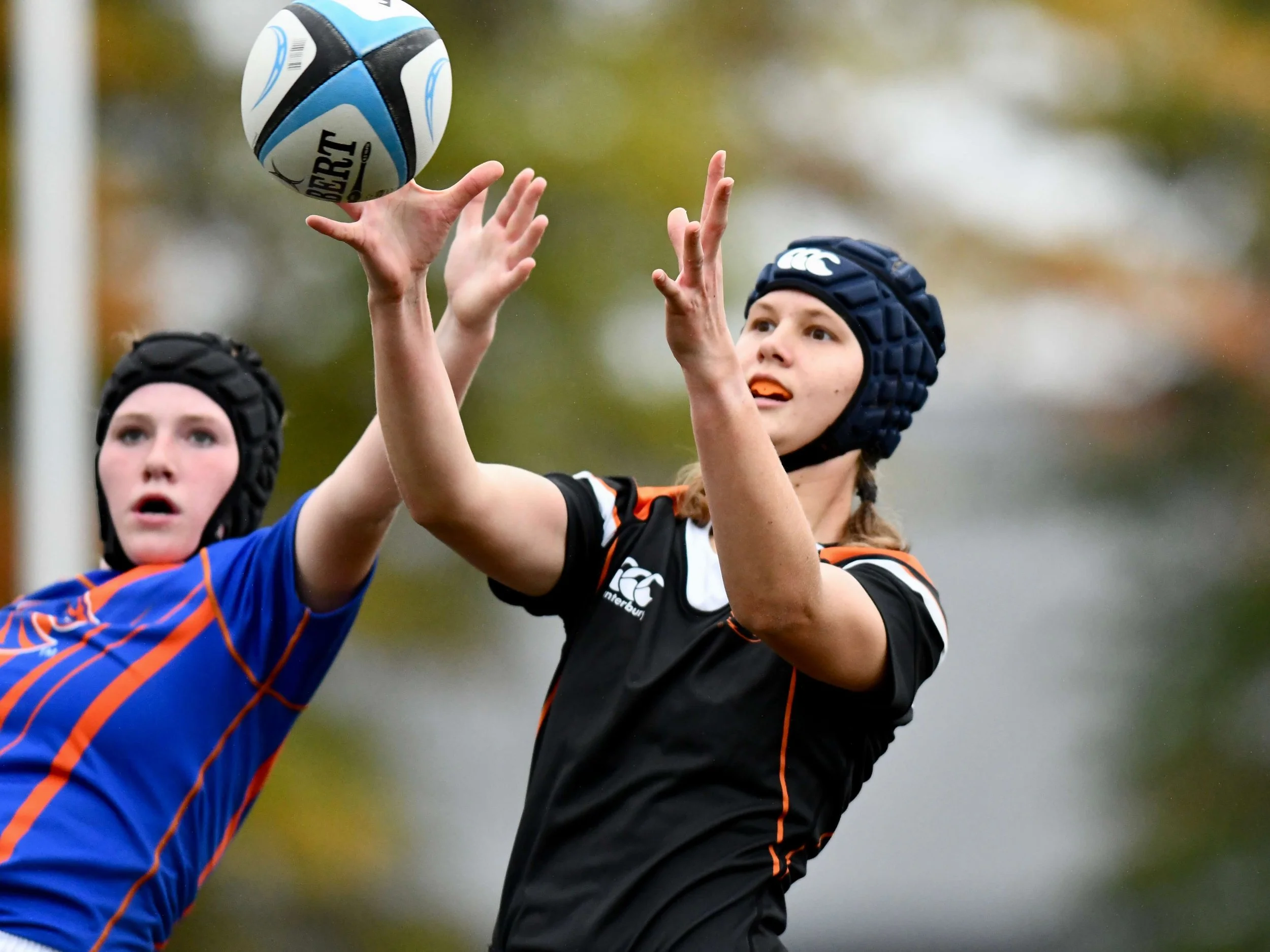 An Oregon State rugby club player looks the ball into her hands during a game against Boise State in 2024 (courtesy Dominic Cusimano)