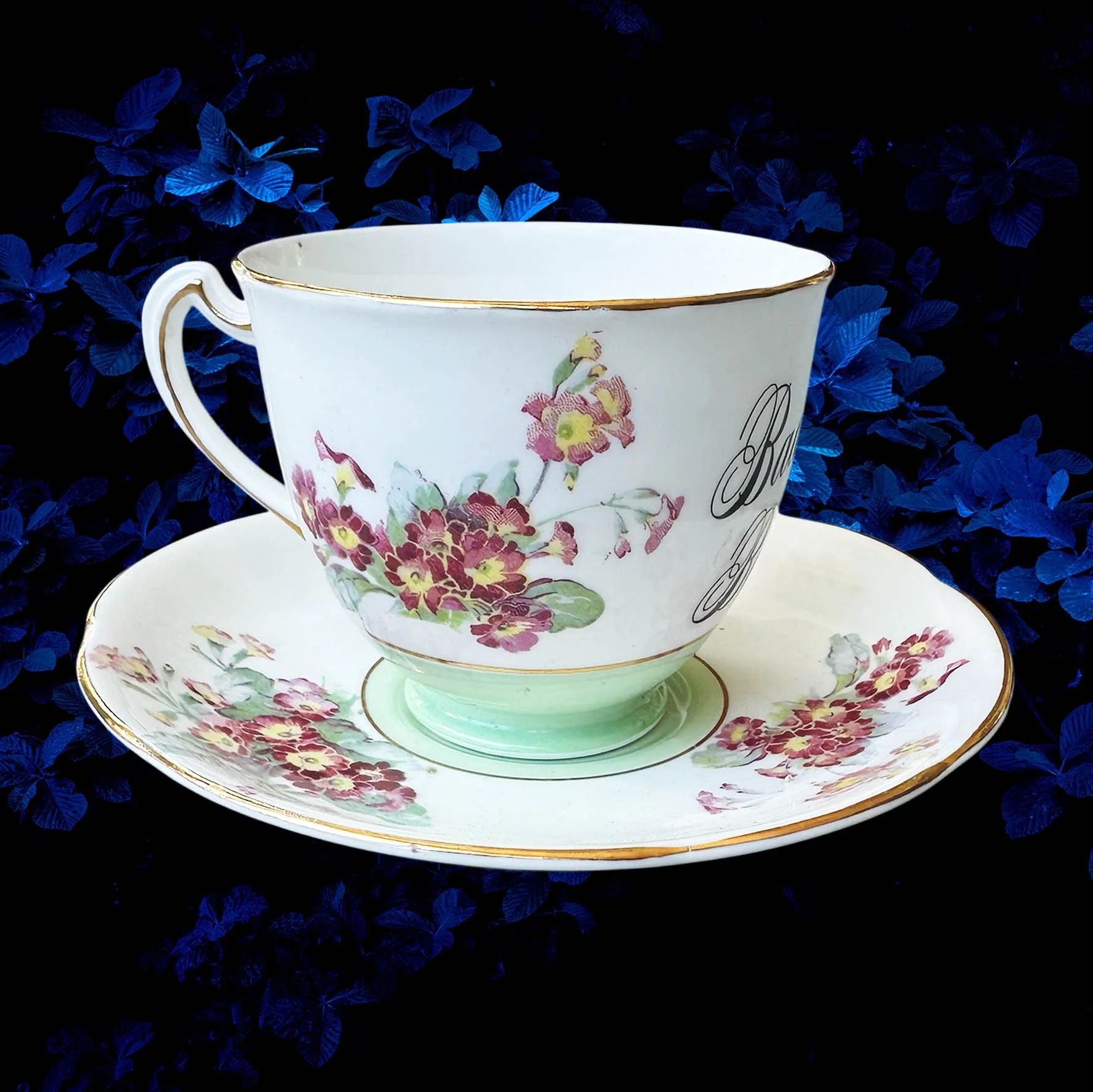 A vintage tea cup with a floral design with the quote “badass bitch”