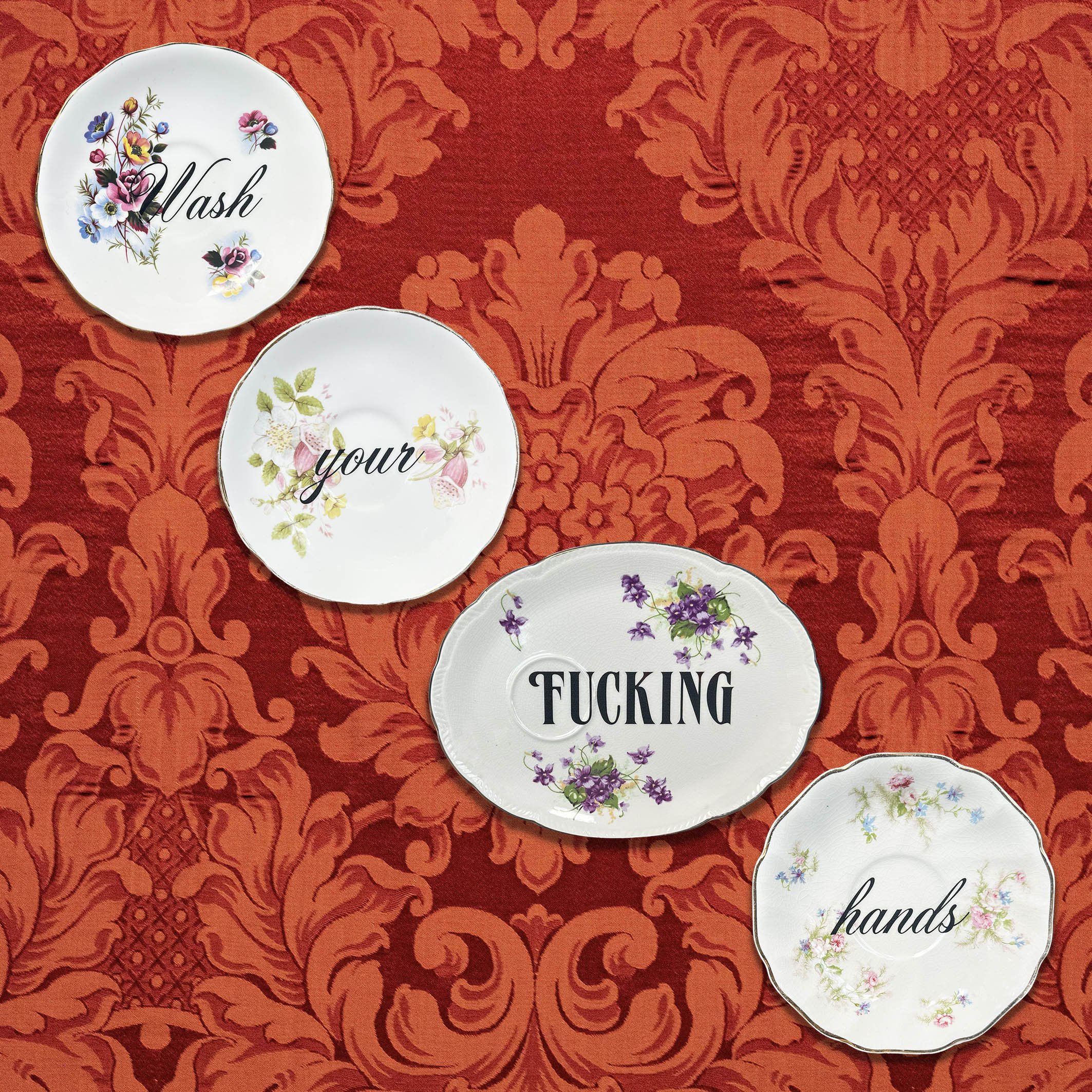 A saucer set to display on the wall with the quote “wash your fucking hands”