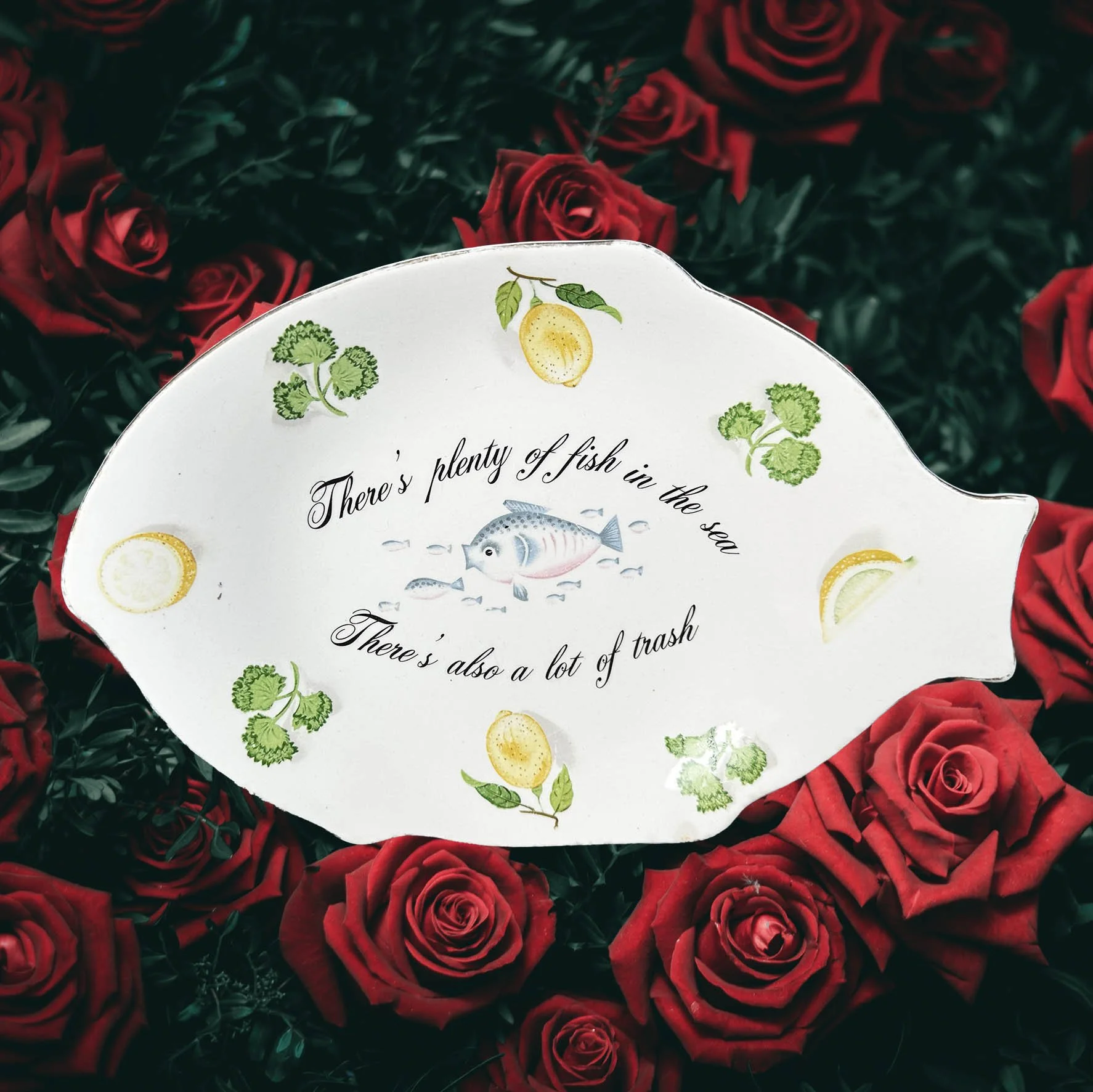 A vintage fish shaped dish with a quote “there’s plenty of fish in the sea, there’s also a lot of trash”