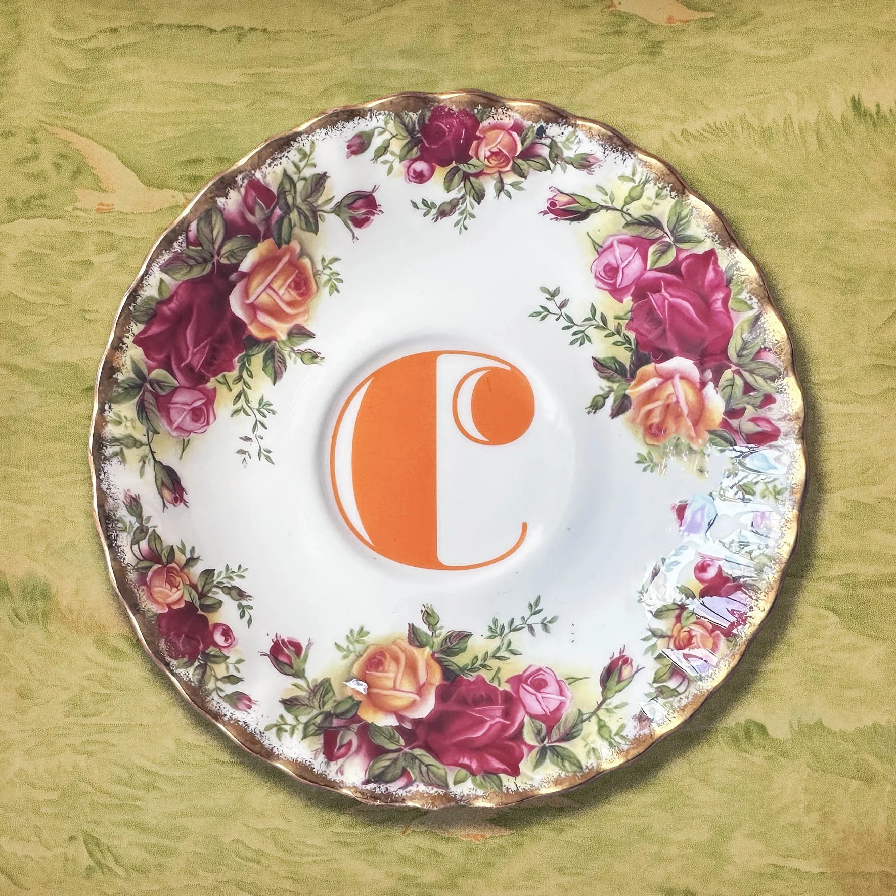A vintage saucer with an orange letter C