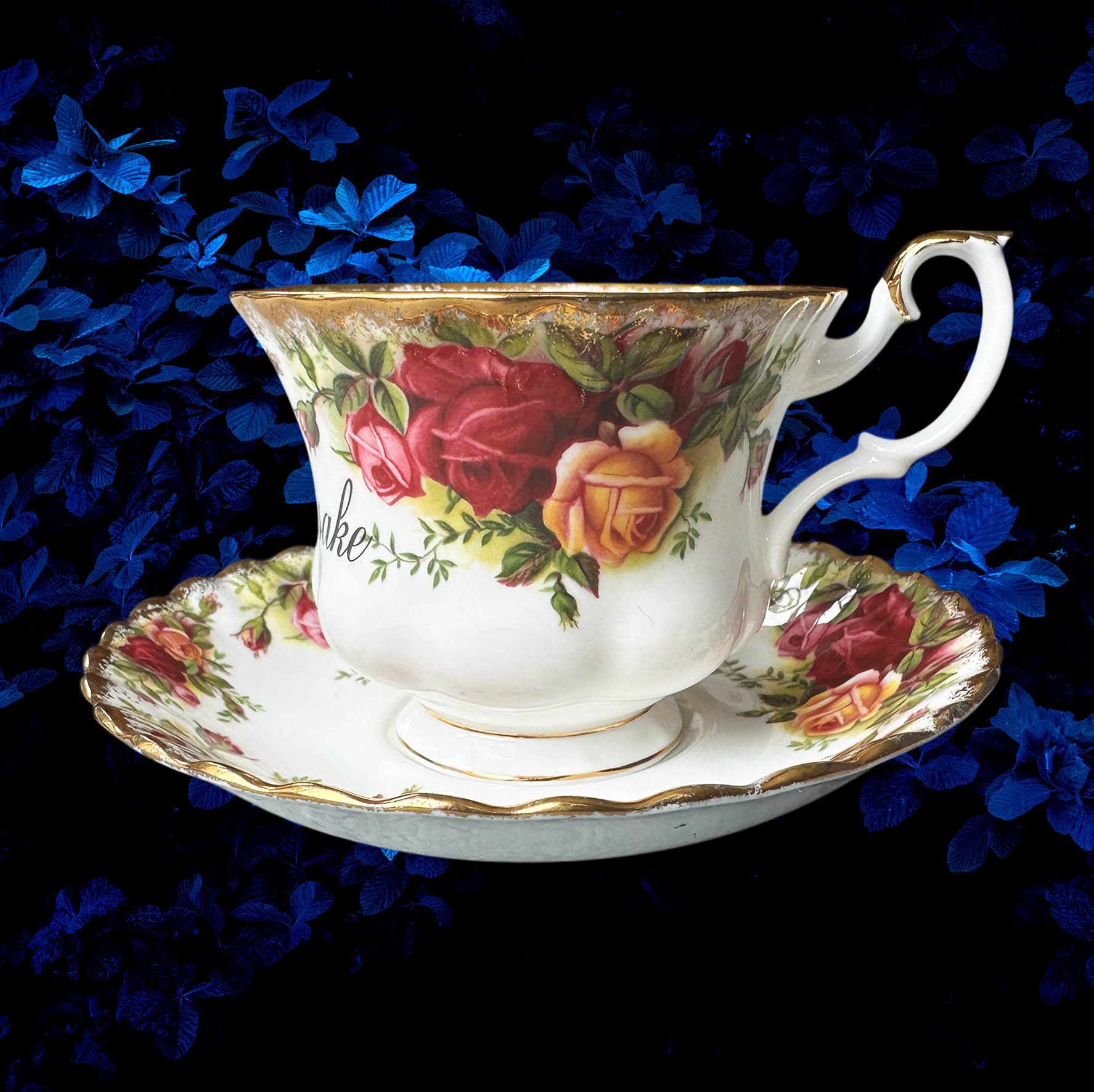 a vintage tea cup with a red rose design and the words "for fuck's sake" in black writing