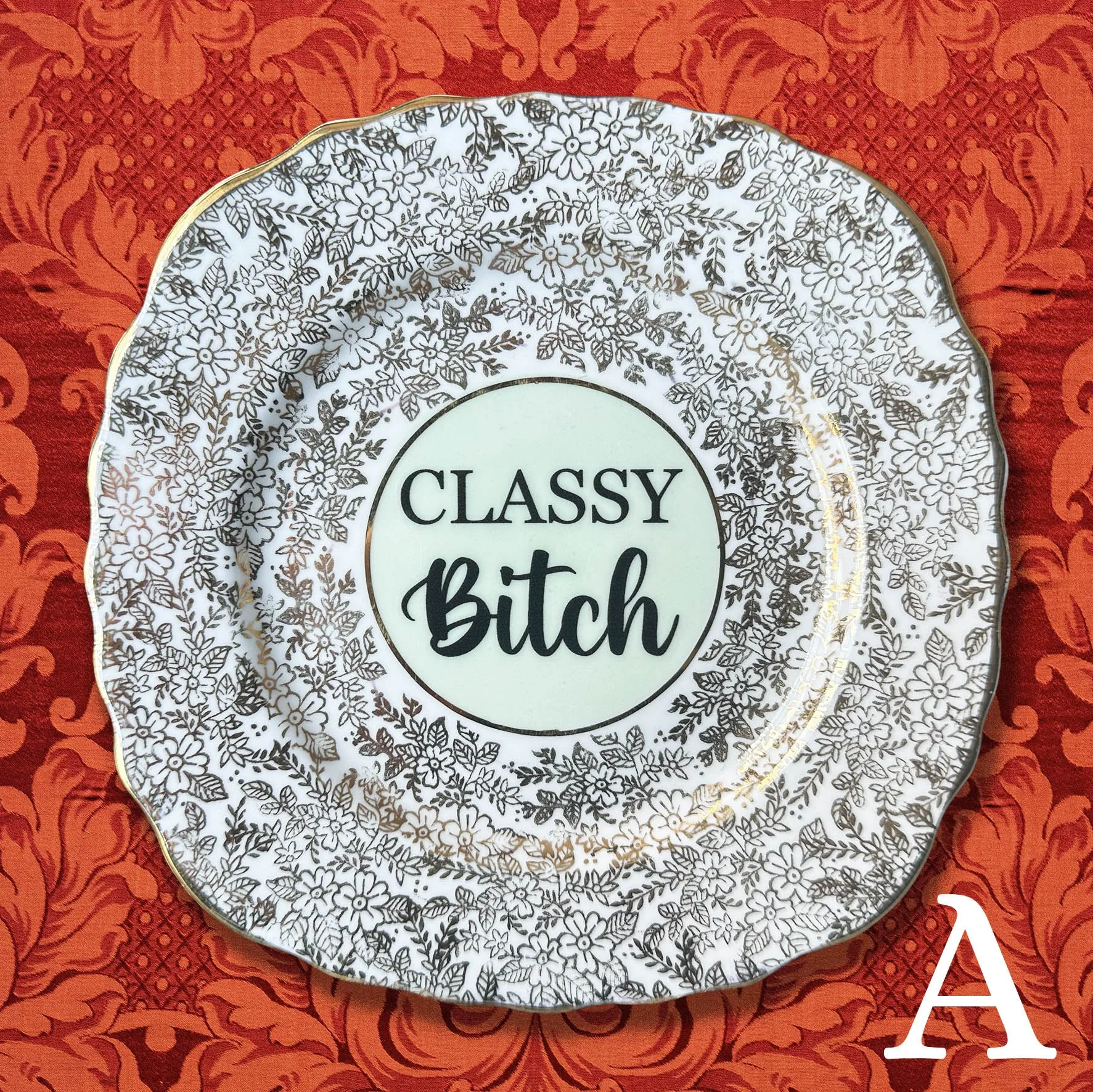 Plate A, a soft green and gold vintage plate with a quote “classy bitch” in black lettering
