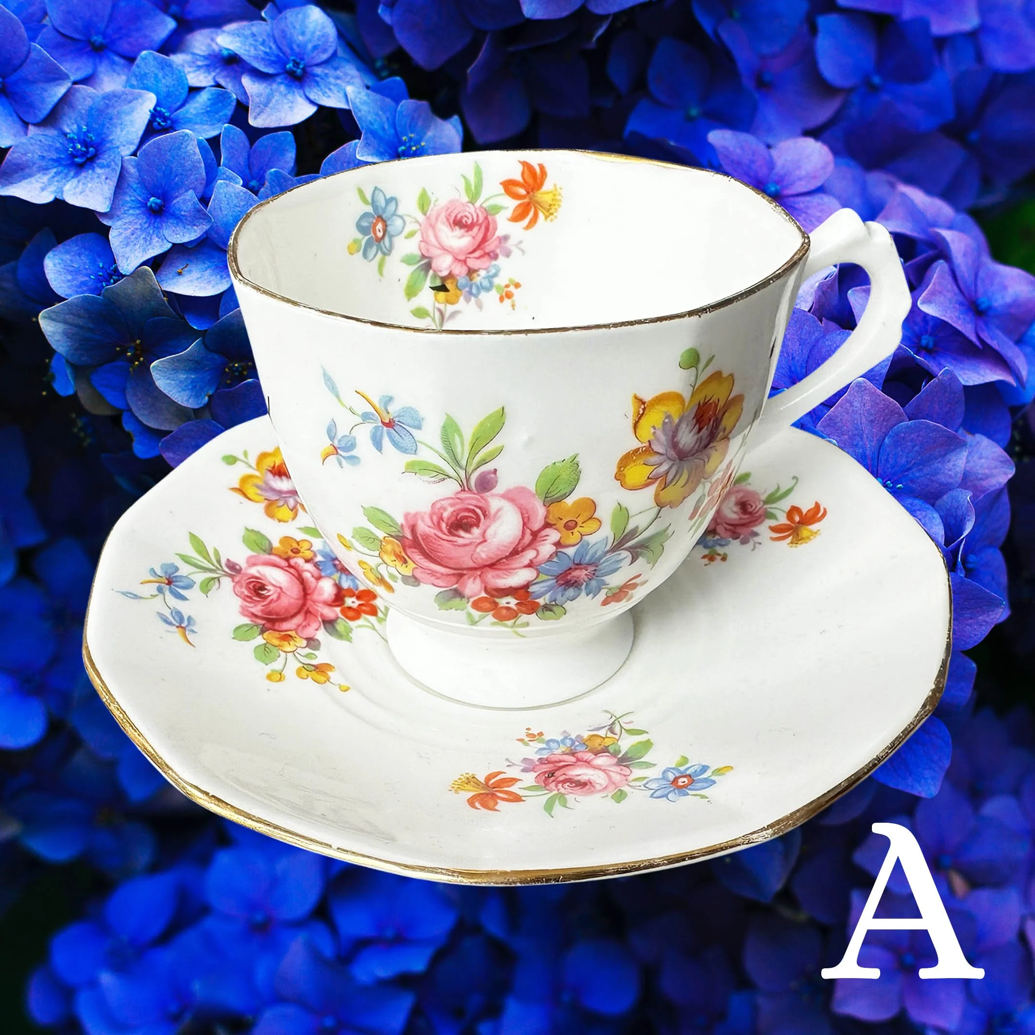 A vintage tea cup with delicate multicoloured flowers and the words “fabulous bitch” in black cursive writing