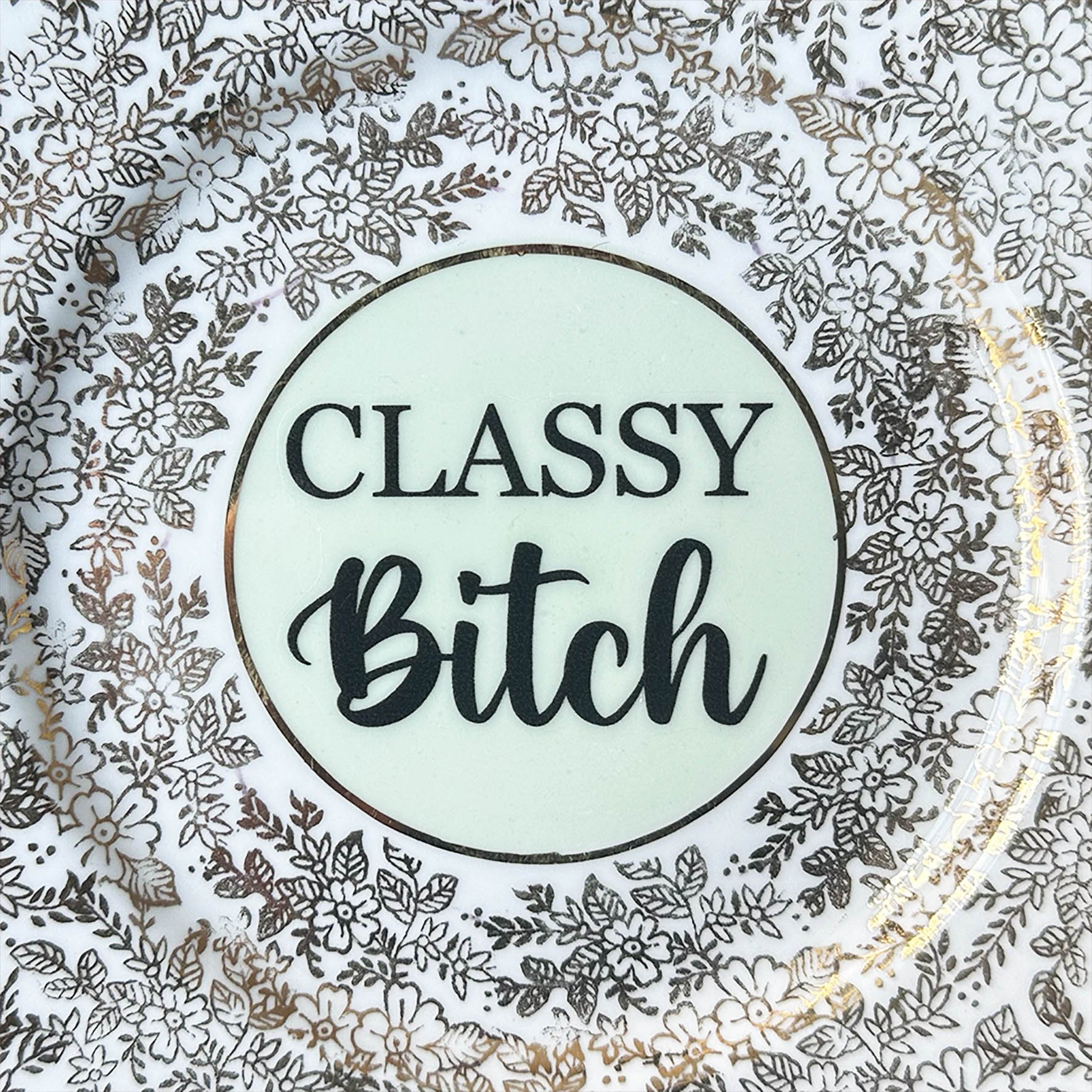 Plate A, a soft green and gold vintage plate with a quote “classy bitch” in black lettering