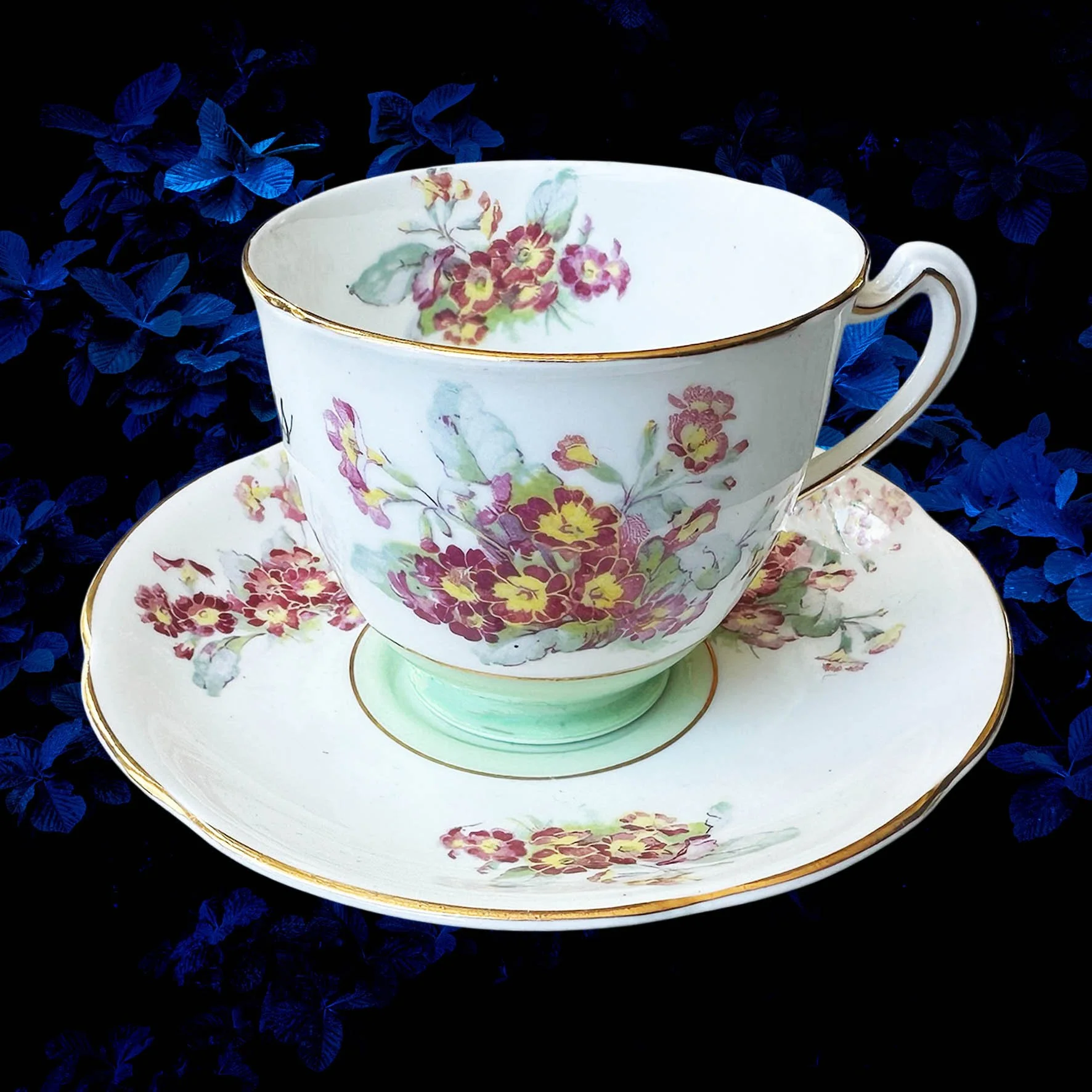 A vintage tea cup with a floral design with the quote “badass bitch”