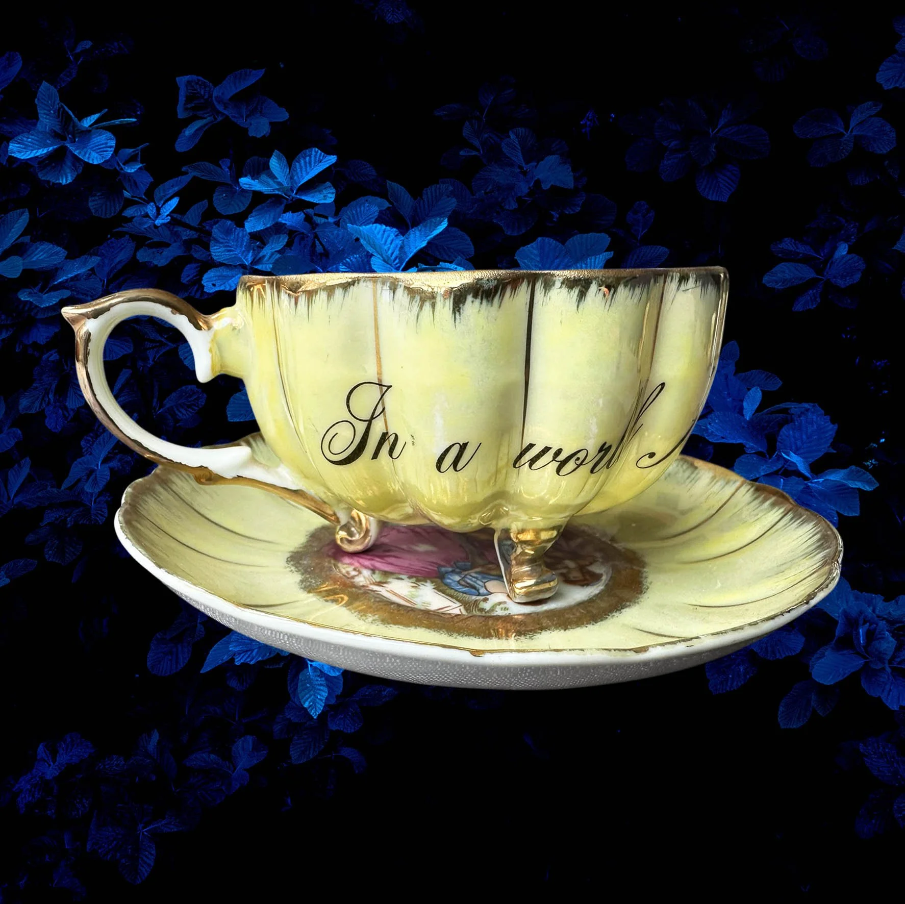A yellow scalloped shaped tea cup with a picture of a couple and the words "In a world full of cunts you're my favourite"