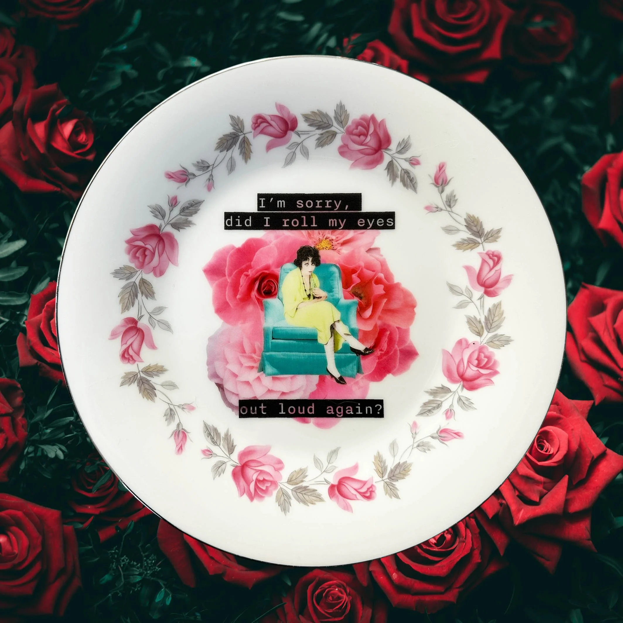 A vintage plate with a pink rose border and a picture of a woman sitting on a blue chair with a drink, and the words “I’m sorry, did I roll my eyes out loud?”