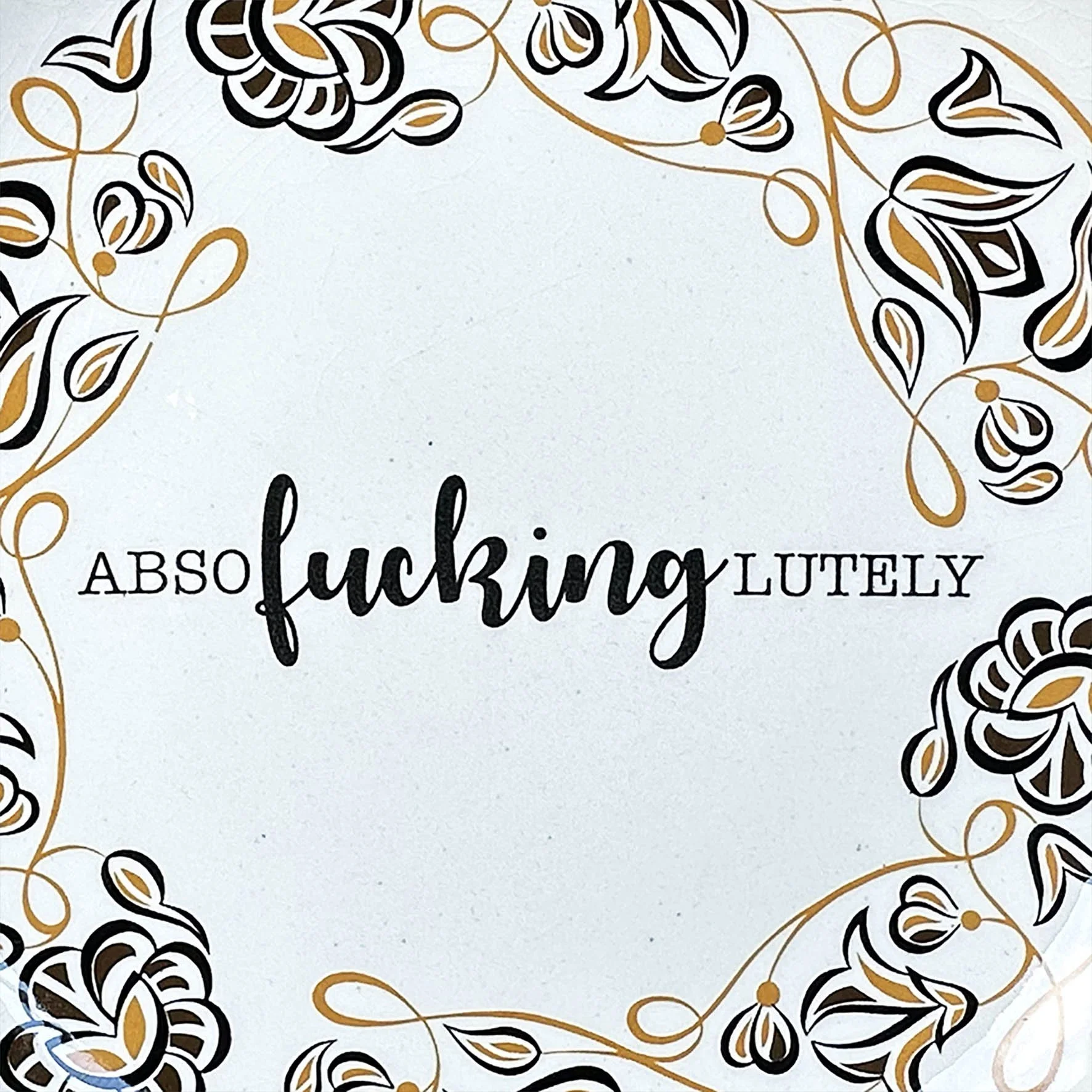 A vintage Poole plate with a black and mustard floral design and the word “absofuckinglutely”