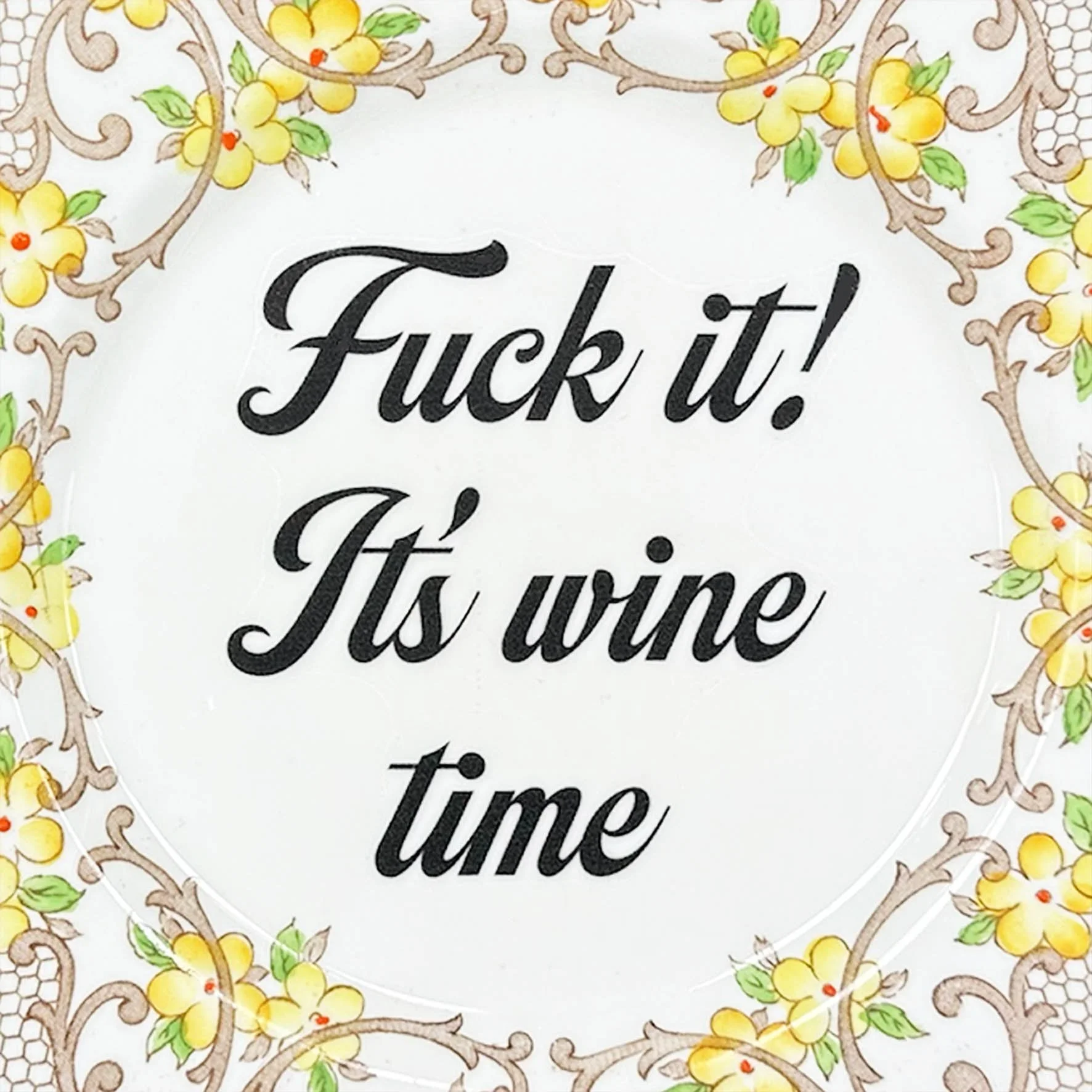 A vintage decorative wall plate with a yellow floral design and the words “fuck it! It’s wine time” in black writing
