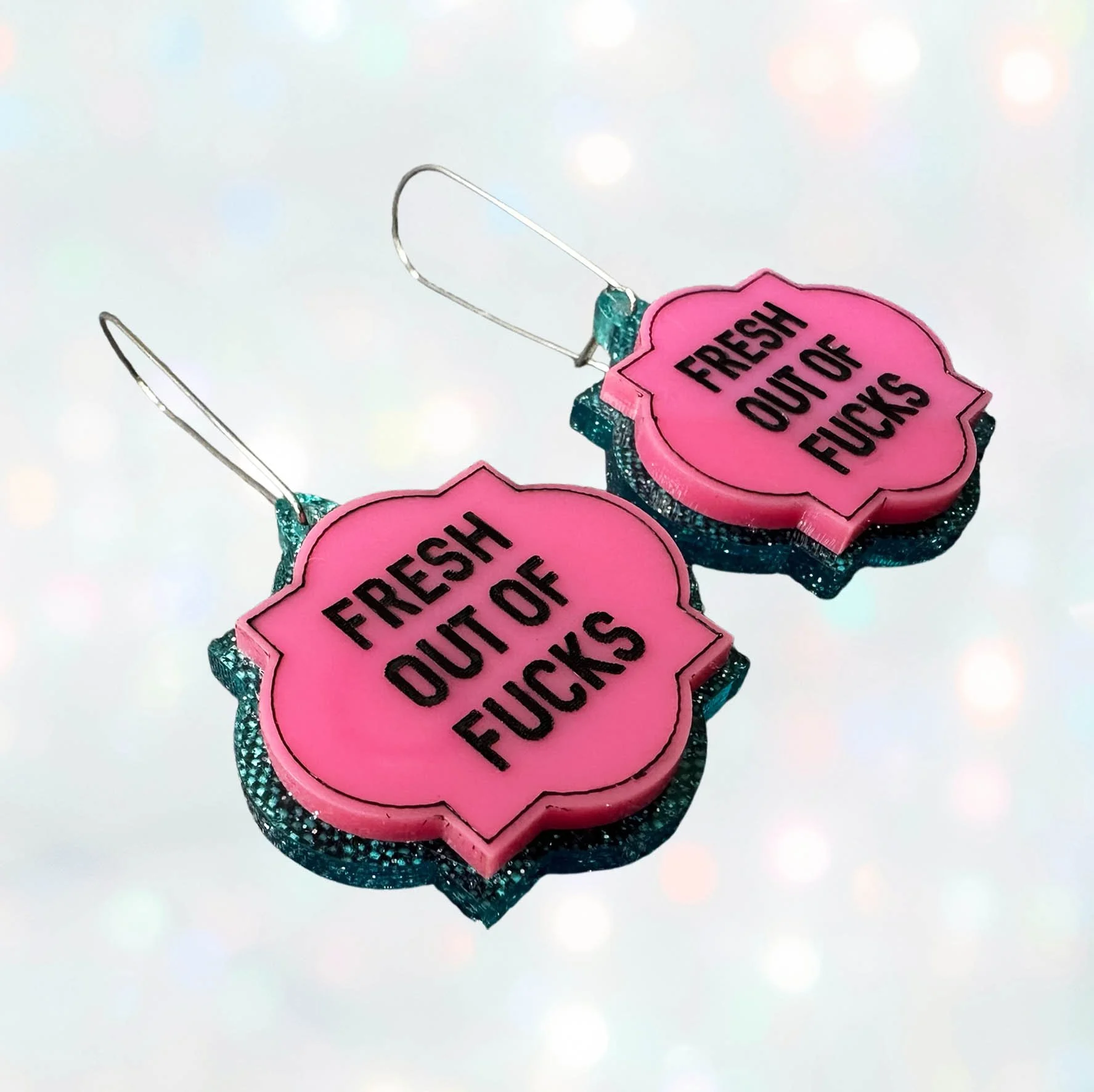 Pink and blue glitter acrylic earrings with the words "kindly fuck off" in black lettering