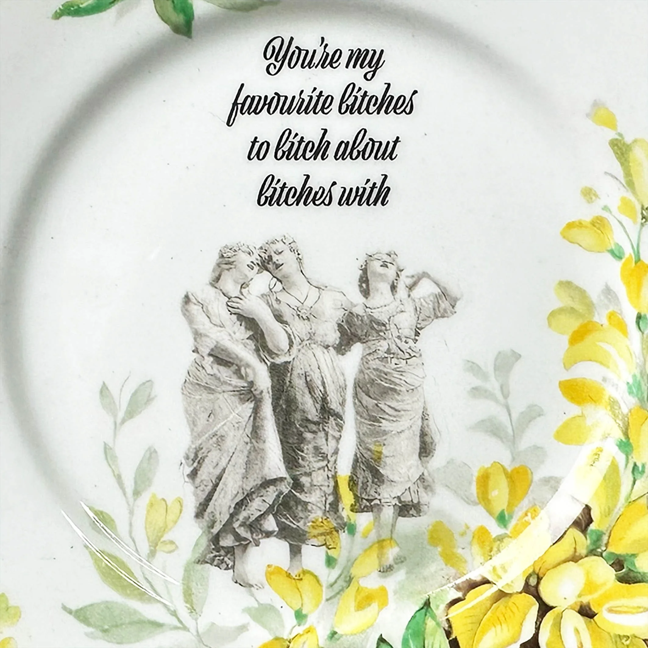Vintage plate with yellow flowers and the image of three women, black writing “you’re my favourite bitches to bitch about bitches with”