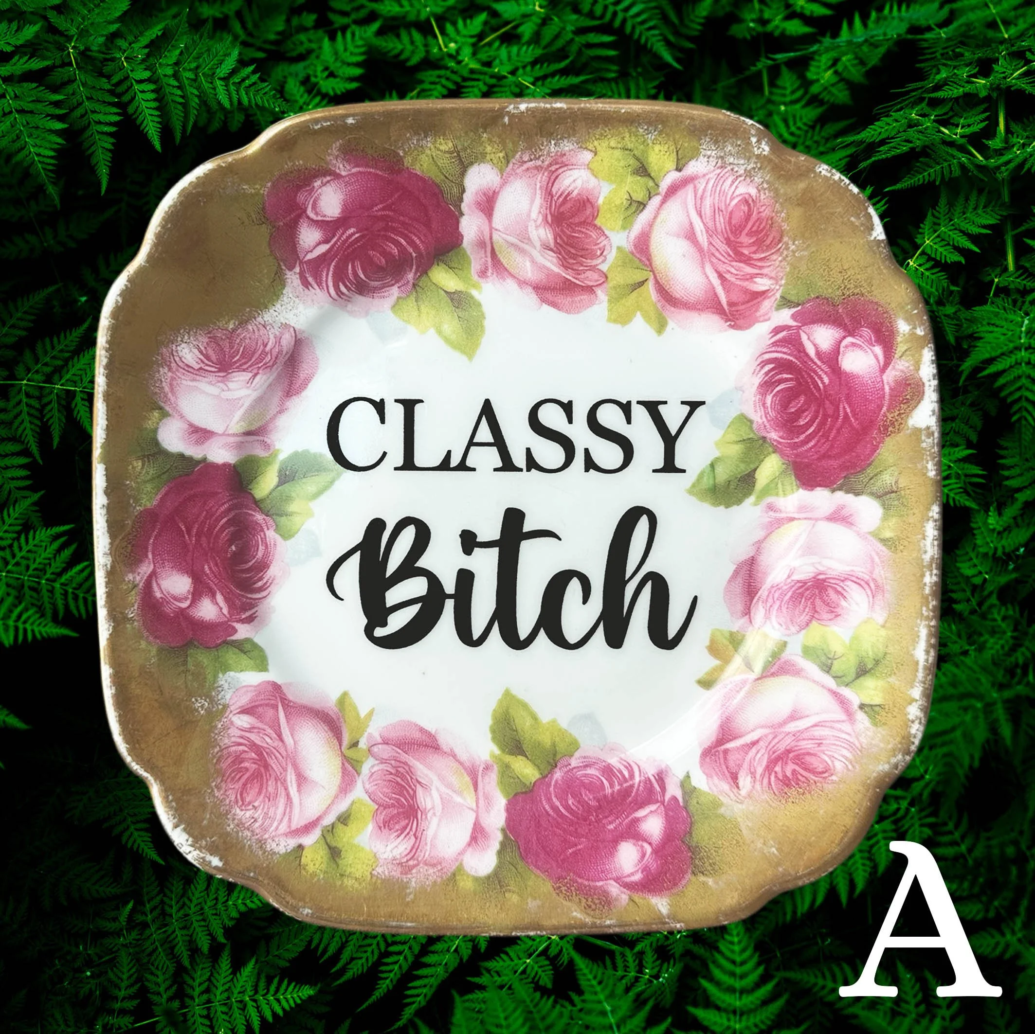 A vintage decorative wall plate with the words "classy bitch" in black writing