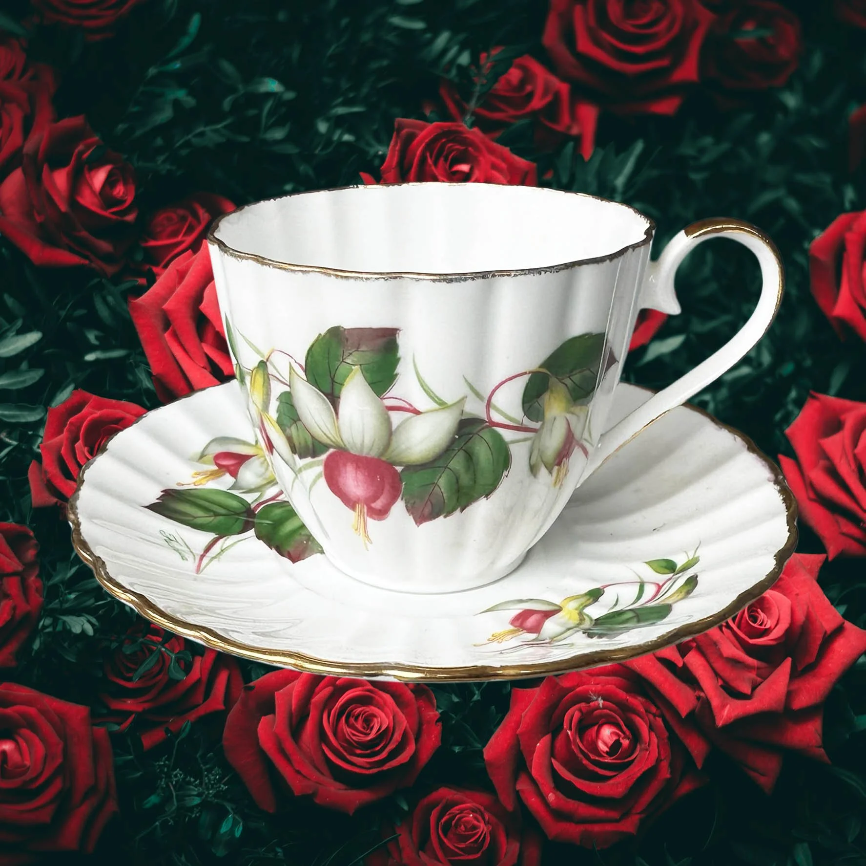 A vintage tea cup with a fuchsia design and the words "don't be a cunt" in black writing