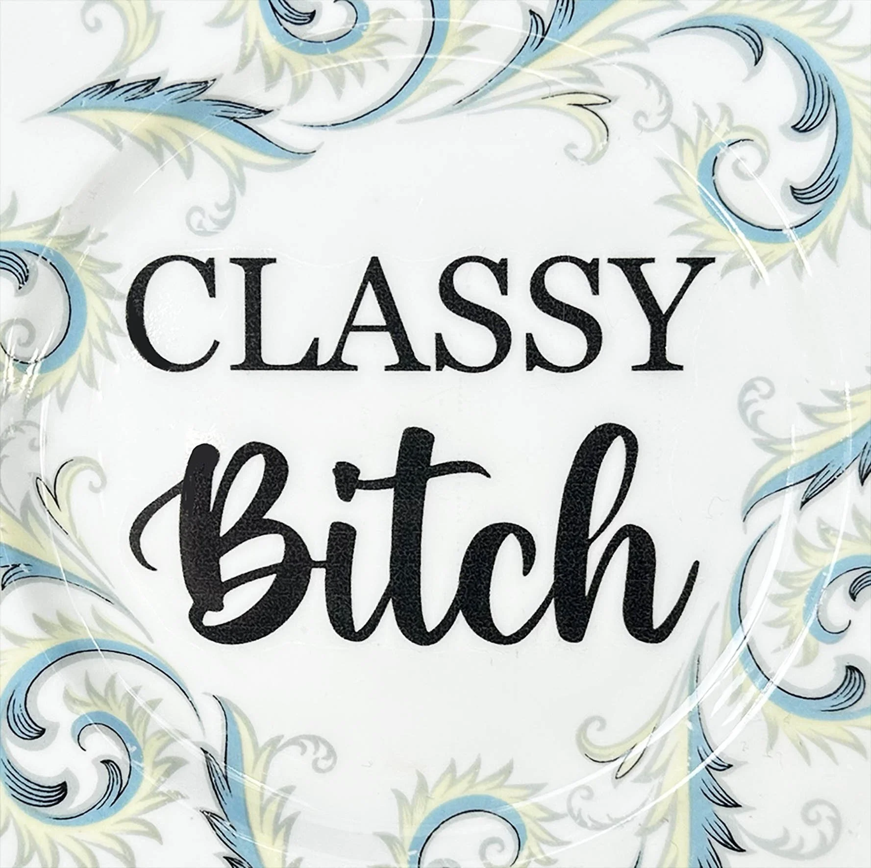 A vintage decorative wall plate with the words "classy bitch" in black writing