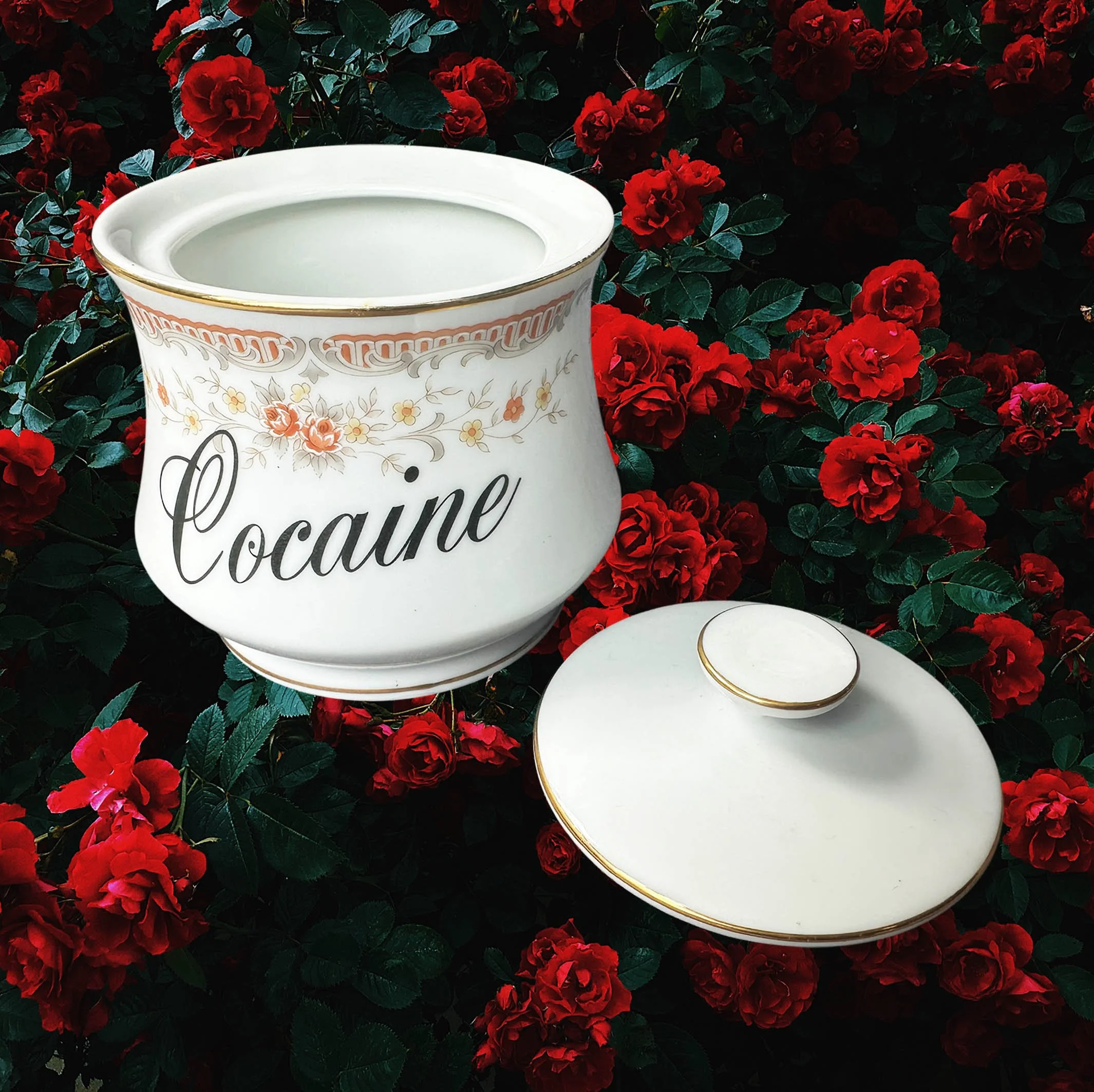 A vintage Japanese sugar bowl with a peach coloured floral design and the words “cocaine” in black cursive writing